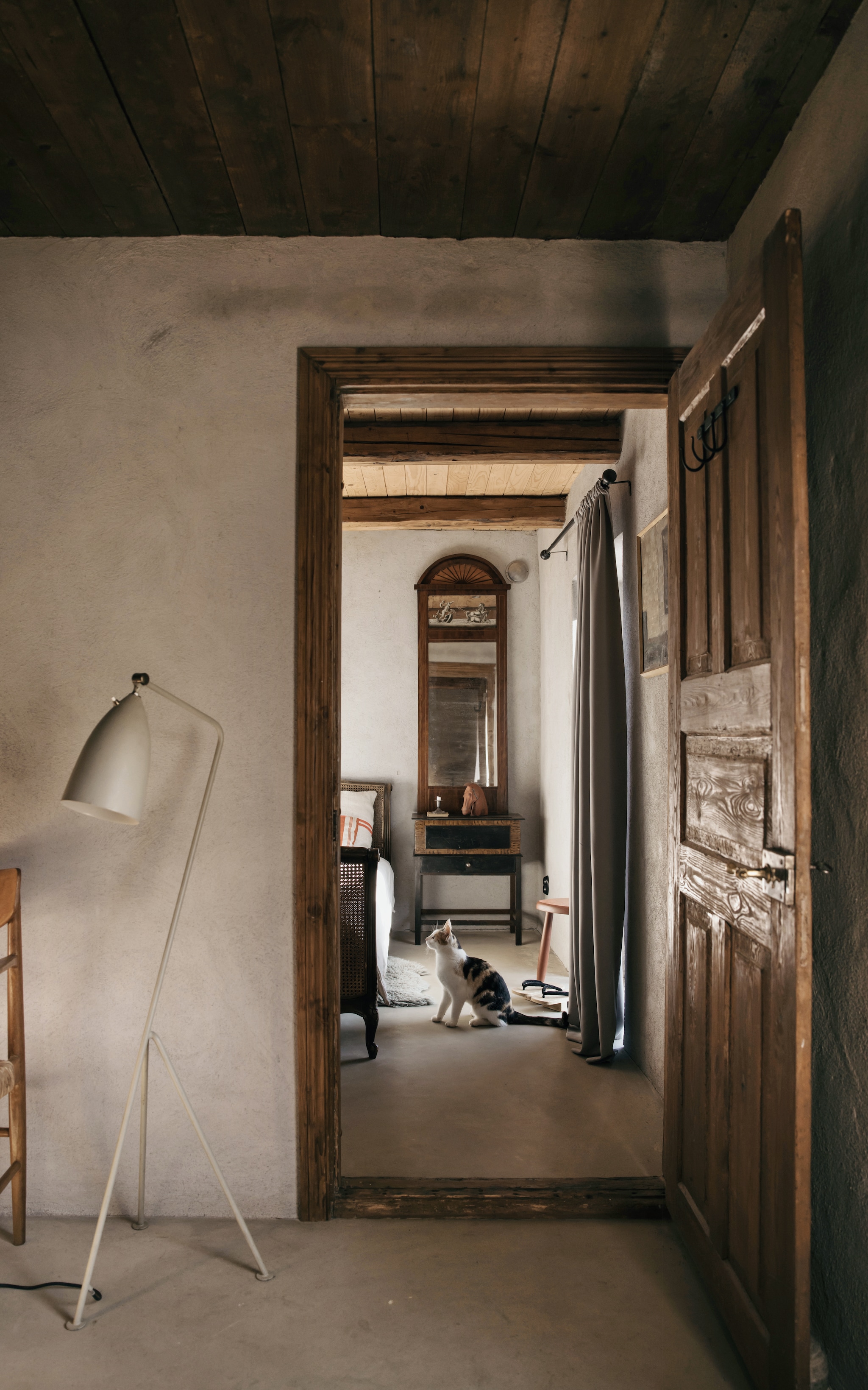 De kleinste slaapkamer in het gastenverblijf. Vloerlamp Grasshopper van Greta Grossman. Antieke spiegel uit de 17de eeuw. vtwonen Landelijk 10-2026 | Styling Karolina Vertus | Fotografie Isabell N Wedin | Productie Living Inside