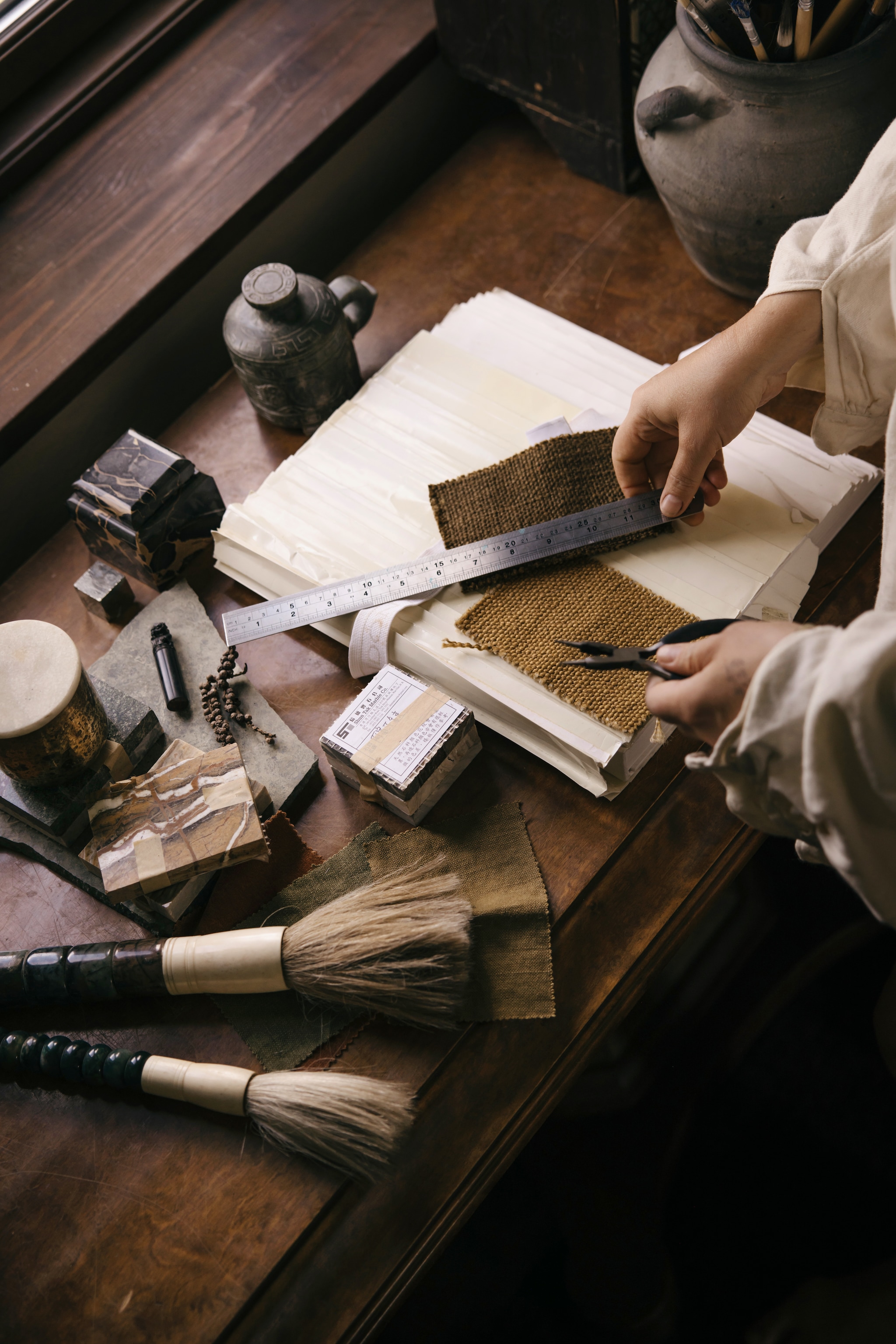 Marmerstalen, kwasten en jade beker met deksel uit Hong Kong. Boek van Taschen. vtwonen Landelijk 10-2026 | styling Karolina Vertus | fotografie Isabell N Wedin | productie Living Inside