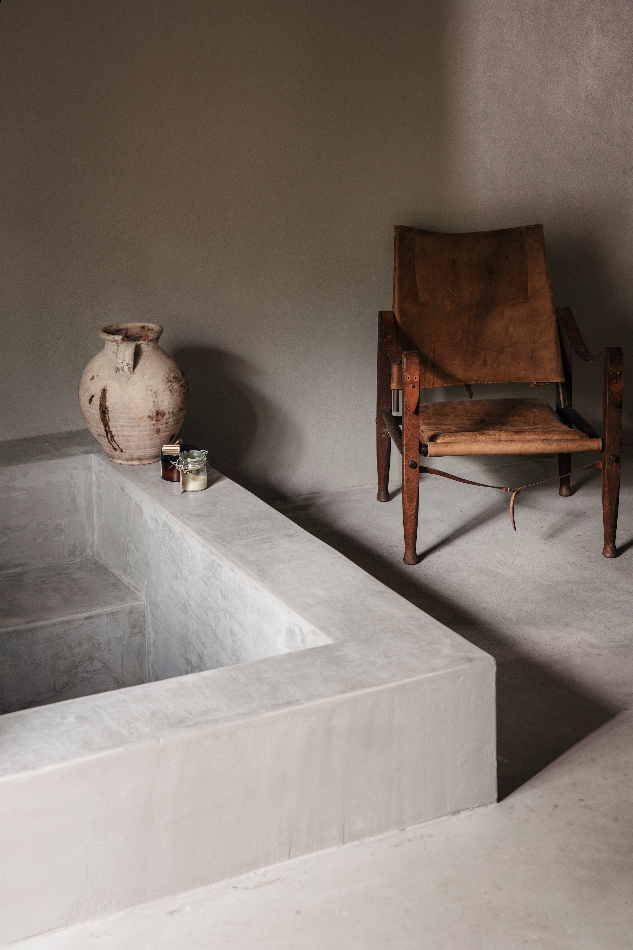 Betonnen bad op maat gemaakt. Antieke pot uit Libanon. Safari-stoel uit 1933 van Kaare Klint. vtwonen Landelijk 10-2026 | Styling Karolina Vertus | Fotografie Isabell N Wedin | Productie Living Inside