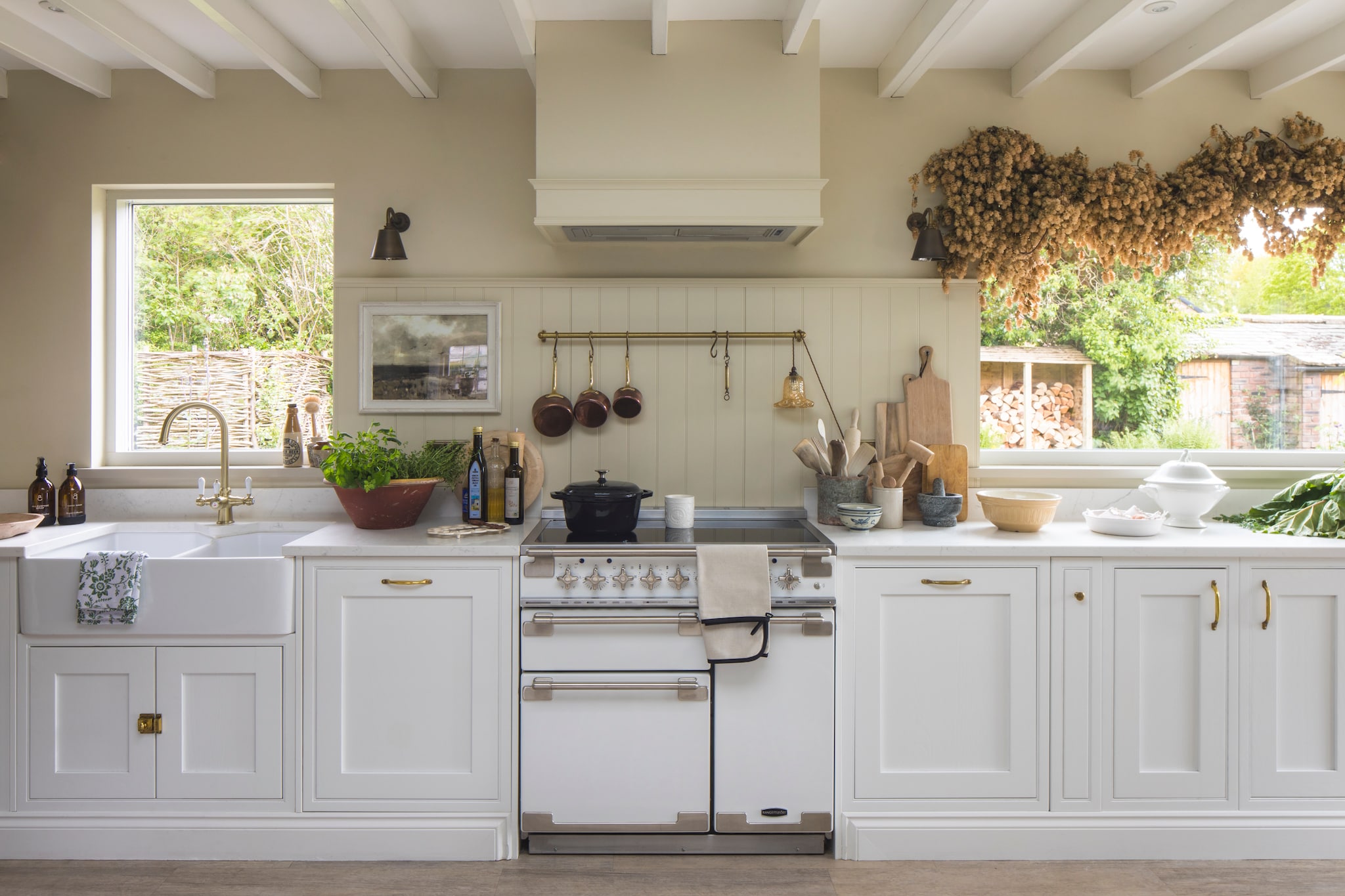 Keuken met Carrara Quartz werkblad van Diy Kitchens. Oven Elise van Rangemaster.  Muur kleur Off-white van Farrow & Ball. Wandlampen Jim Lawrence. Vloerkleed Zara Home. vtwonen Landelijk 10-2026 | styling Marisha Taylor | fotografie James French | productie Living Inside