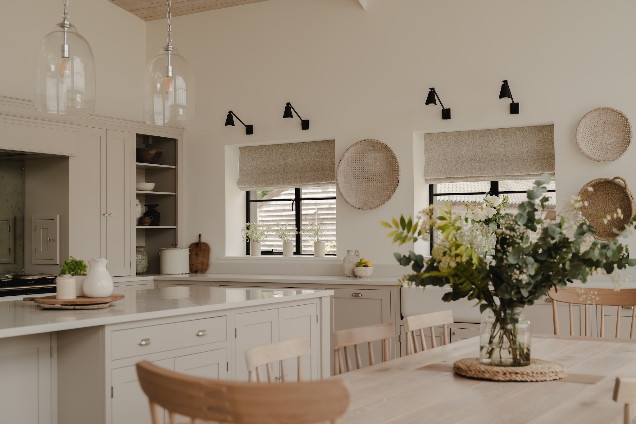 Hanglampen Neptune. Wandlampen Lum’art. Soortgelijk: manden Bylebon, vazen Nordic Nest, borrelplank Xenos, plantenpotten Loods 5, spijlenstoelen Retro Studio.Raamdecoratie gemaakt met stof van Romo en Fermoie door Annabelle Bowman-Shaw van Nans Design. Gelakte houten keukenkasten op maat. Werkblad van kwarts. vtwonen Landelijk 09-2026 | styling Camilla Brogaard | fotografie Joey Kendal Brown