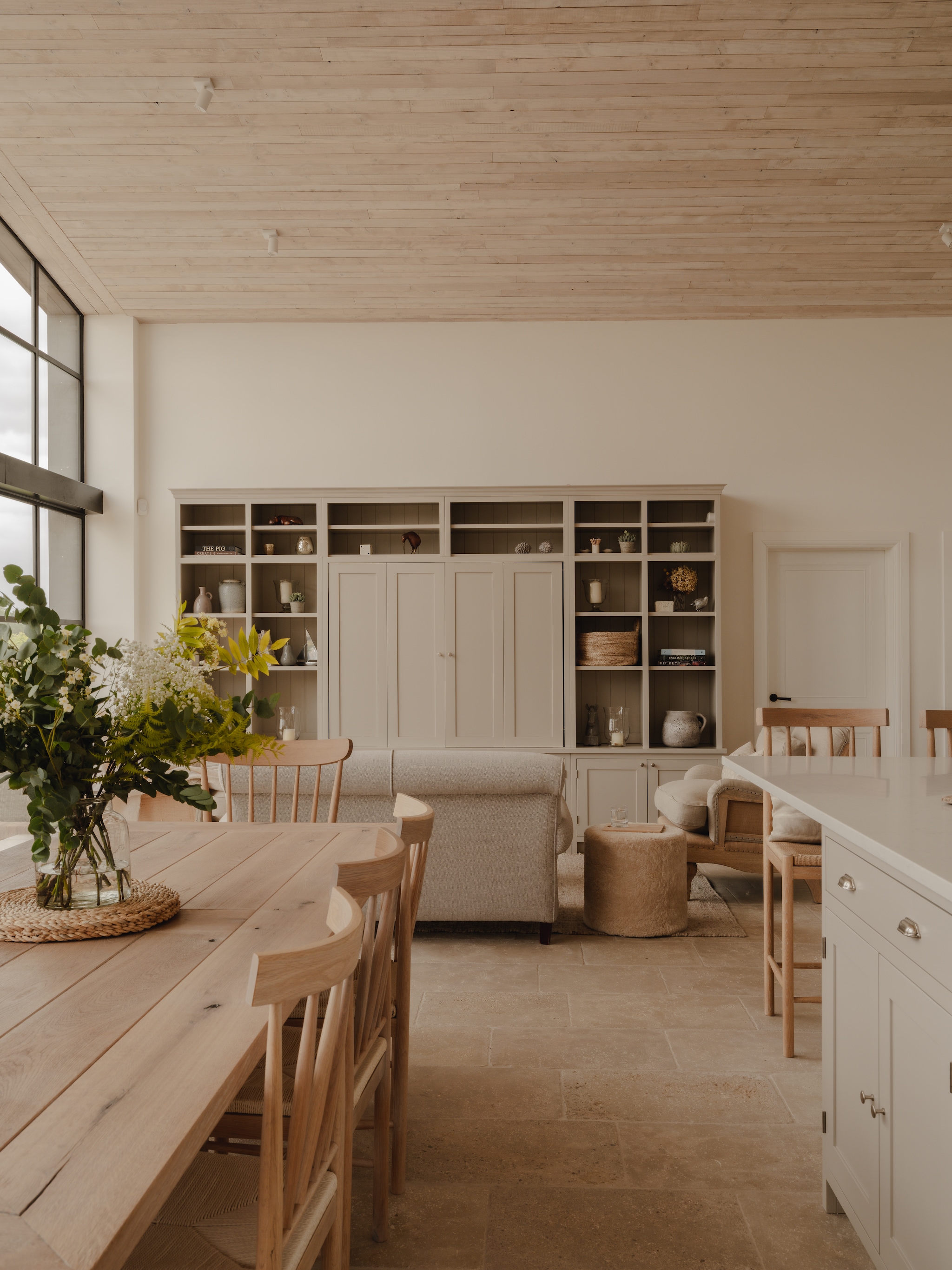 Plafondmateriaal The Main Company Keukenfronten en grepen Rowen & Wren. Verf keuken en kasten Driftwood. Eettafel ontworpen door Camilla.  Stoelen Neptune. Vloertegels Ca’ Pietra. Soortgelijk: bank Habitat. poef Hyde & Hare, onderzetter en vaas op tafel Nordic Nest, barstoel Loods 5. Grote decoratieve objecten in de kast in de loop der jaren verzameld. vtwonen Landelijk 09-2026 | styling Camilla Brogaard | fotografie Joey Kendal Brown