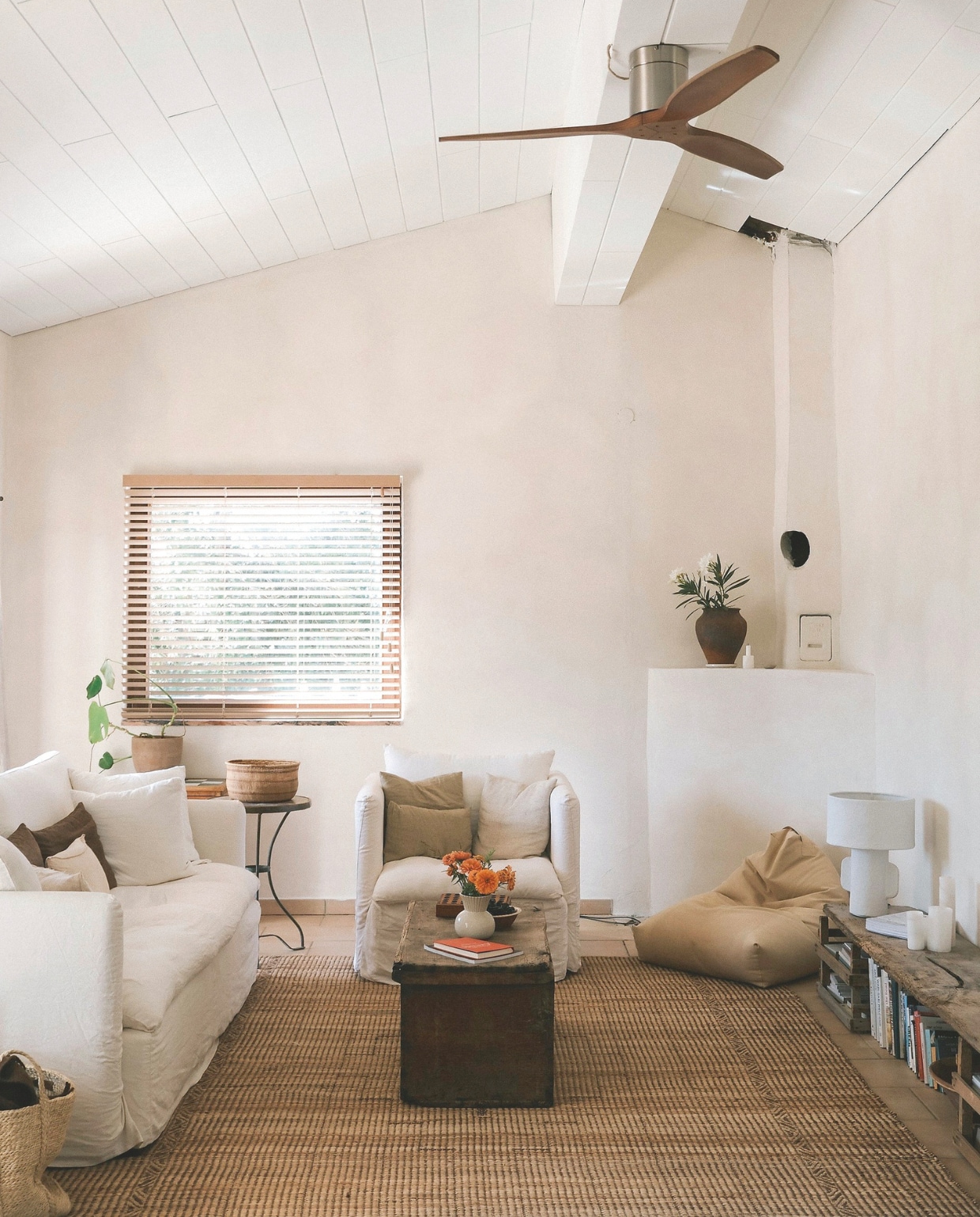 Kalkverf Bone van Bauwerk Colour. Linnen bank en fauteuil Zoco Home. Kussens Tell Me More, Maison de Vacances en Isabelle Yamamoto. Vloerkleed HKliving. Salontafel antiek. Bamboe jaloezieën Lattestore. Poef Zara Home. vtwonen 08-2026 | fotografie Isabelle Vermeersch