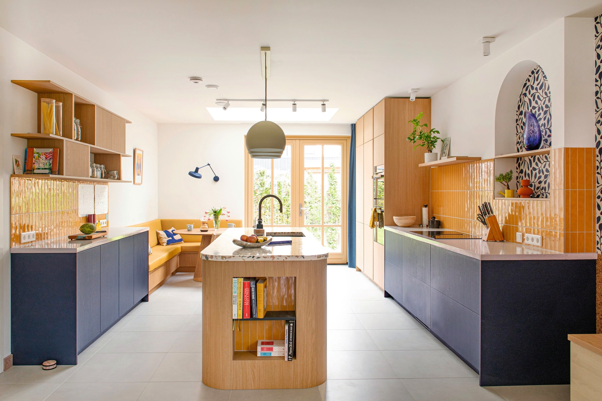 Keuken en bank Jorik Maakt. Tegels Luz Giallo van Marazzi.  Plafondlamp Jaicey van Light & Living. Maatkussen bank in Linnenlook Yellow door Nofruit. Wandlamp Arigato van Grupa. Muurkleur Wevet van Farrow & Ball. vtwonen 7-2026 | fotografie Caroline Coehorst