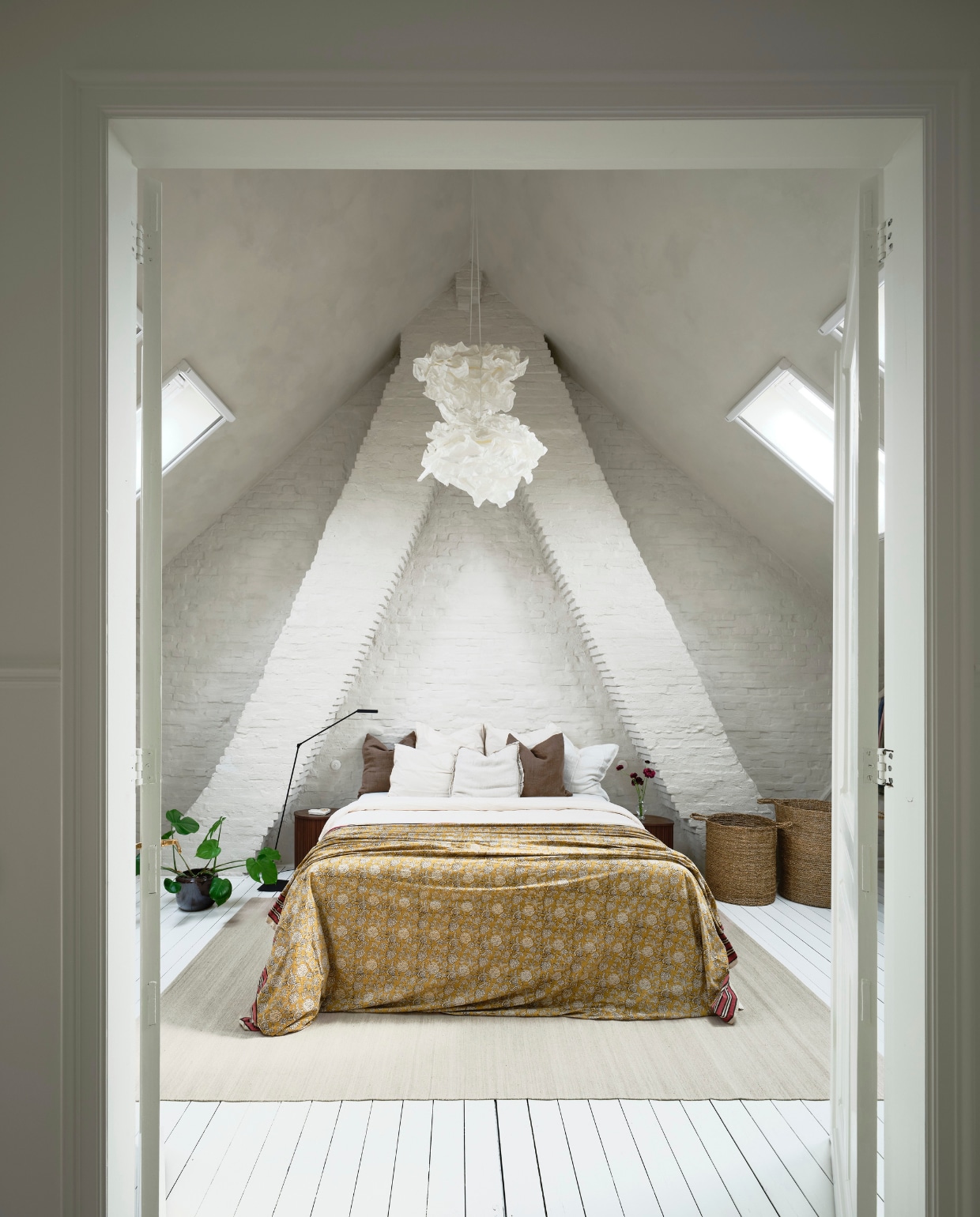 Verf muren en plafond Damico Dune van By Anouk. Hanglampen Ikea. Vloerlamp en vloerkleed Zara Home. Nachtkastjes H&m Home. Bloempot Serax. Bedsprei Doing Goods. Manden online vondsten. Originele plankenvloer, geschilderd in Ral 9010. vtwonen 07-2026 | fotografie Mr. Frank