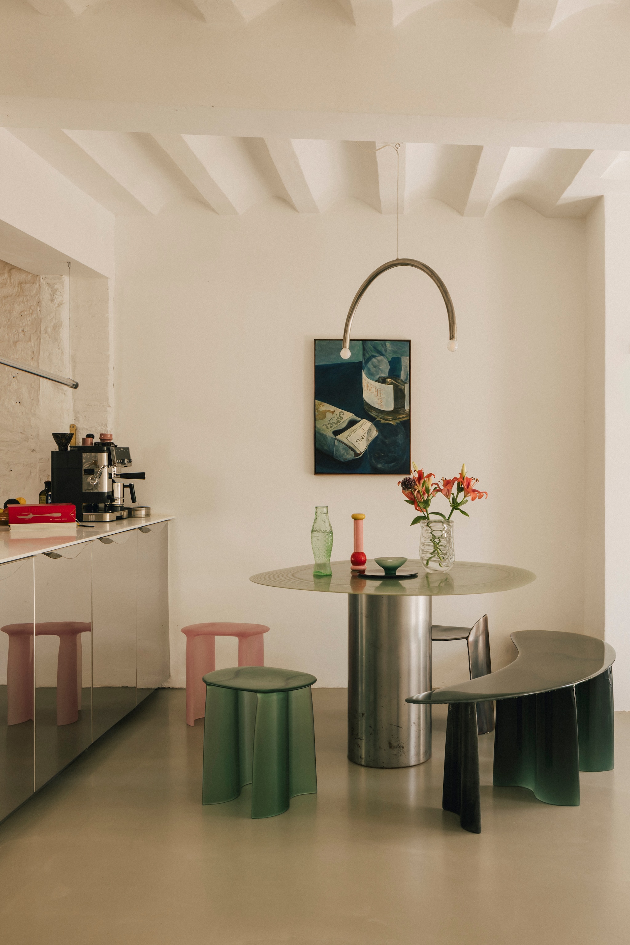 Tafel Pillar Table en bankje en linker kruk New Wave Curved Bench. Rechter kruk Calle van Christian Fregnan. Messenhouder aan de wand Maximilian Michaelis. Waterkaraf Fish & Fish van Paola Navone voor Serax. Pepermolen Mp0210 Alessi. Schaal Fiberglass van Lukas Cober. Hanglamp Rainbow van Hannah Kuhlmann. Bankje links New Wave SC bench van Lukas Cober. Kunstwerk Karel Dicker. vtwonen design 8-2026 | Fotografie Katoo Peeters