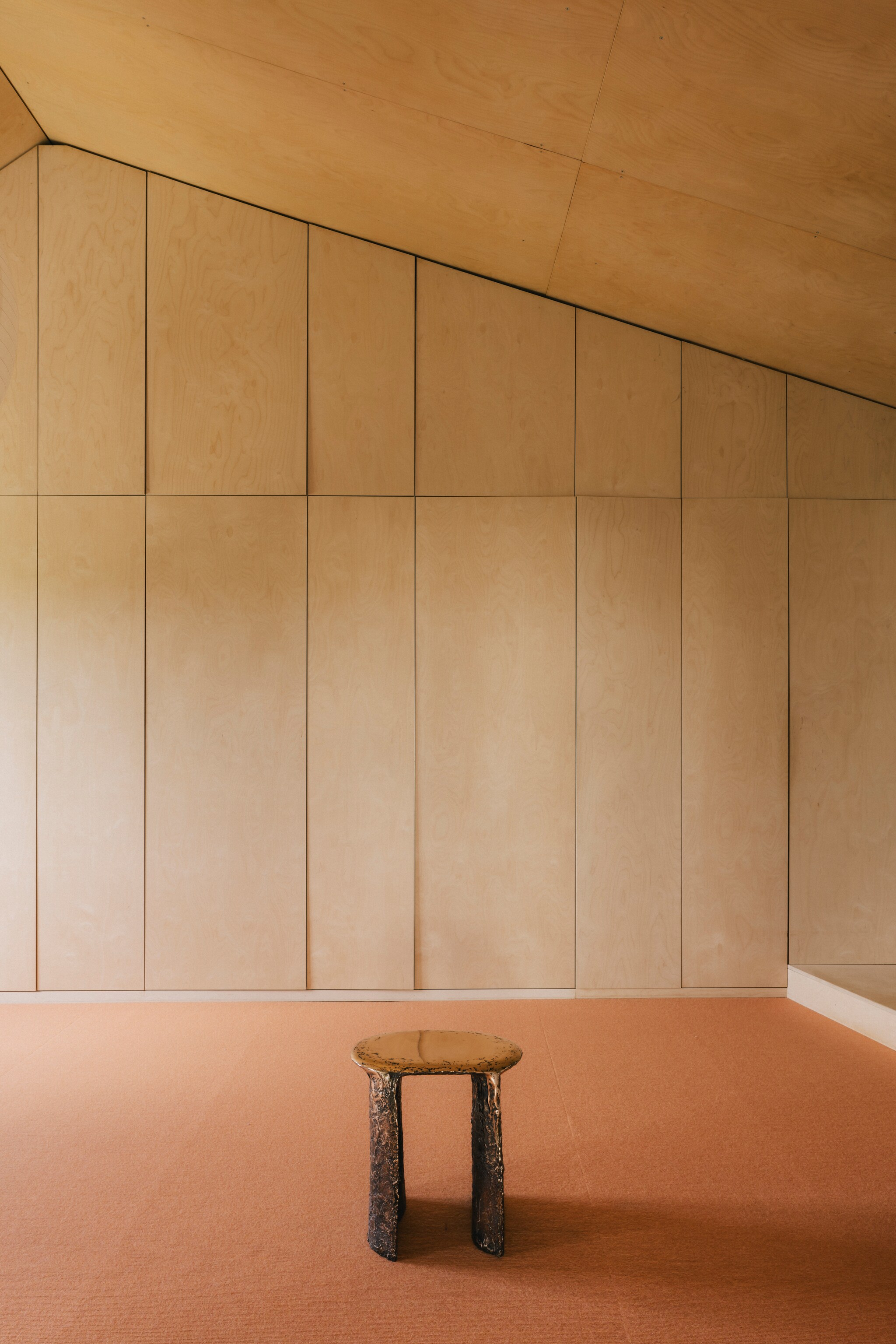 Tapijt Tretford. Originele kozijnen uit het landhuis waar dit huis deel van uitmaakte, gebrand en in de was gezet. Kruk Liquid Bronze van Lukas Cober. vtwonen design 8-2026 | Fotografie Katoo Peeters