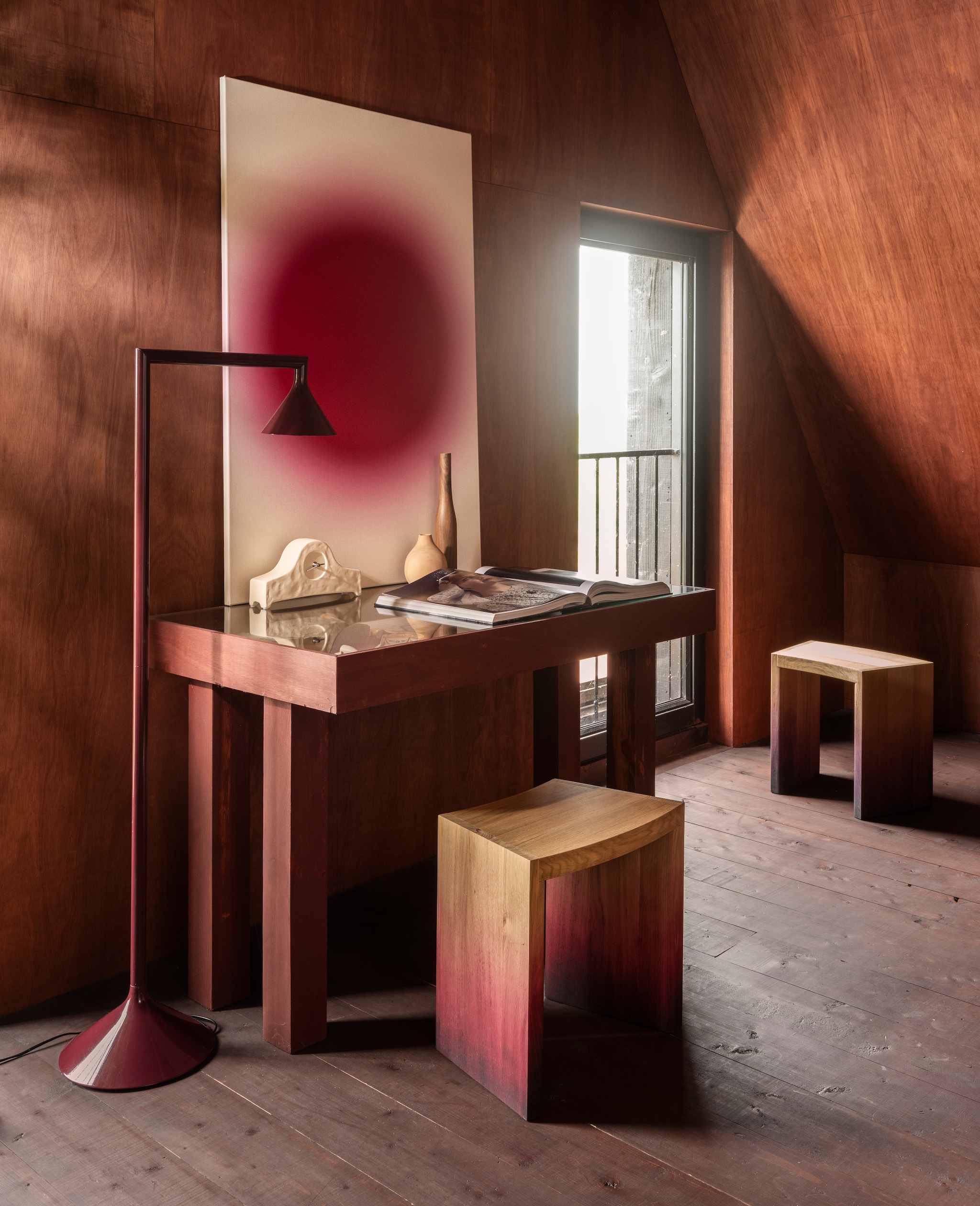 Onno Adriaanse kruk Dawn, eiken, dégradé rood en paars, 32x43,5x54 cm (lxbxh) € 1000,- (onnoadriaanse.nl). Ikea PS 2026 lamp Uplight by Lex Pott, metaal, donkerrood € 39,99 (ikea.nl). Dina Dankers kunstwerk, neonkunst, canvas, wijnrood/wit € 345,- (werkaandemuur.nl). Zuiver klok Grandma, keramiek, roomwit € 59,- (shop.vtwonen.nl). Pilat & Pilat  vaas Stilleven, iepenhout, naturel € 52,-, vaas Stilleven, walnoot, bruin € 43,- (pilat.nl). Jimmy Nelson boek Between the Sea and the Sky € 125,-(jimmynelson.com). Wand afgewerkt met Linolie lijnzaadolie, satin wood oil rom, rood, prijs op aanvraag (linolie.dk). Overig privébezit. vtwonen 10-2026 | styling Marianne Luning | fotografie Stan Koolen