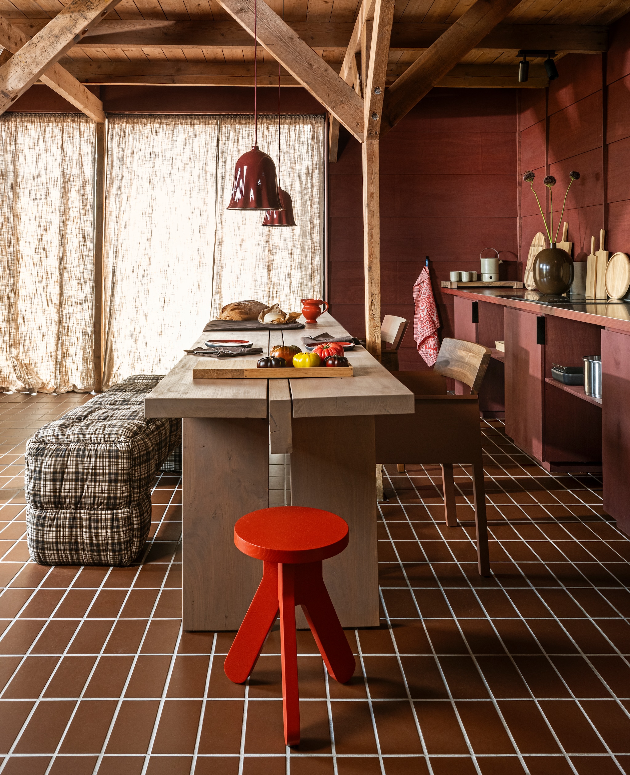 Ateliernvmbr lamp Ciao Bella, keramiek, donkerrood € 269,- (ateliernvmbr.nl). HKliving bank Puffy lobby bench, textiel, bruin/wit ruit, 140x40x45 cm (lxbxh) € 425,-,  Farmhouse ceramics kan, keramiek, oranje € 30,95, Farmhouse ceramics borden, keramiek, oranje, set van 2 € 29,95, No2 by Esther kan met oor, 3D-geprint gerecycled hout, bruin € 49,- (no2byesther.nl). Pilat & Pilat stoel Lio, iepenhout, naturel en donkerrood € 1060-, kruk Syl, eikenhout, rood € 365,-, dienblad Neeltje, eikenhout, naturel € 82,-, snijplank Durk Lutzen, rond, walnoot, naturel € 65,-, snijplank Durk Lutzen ovaal, walnoot, naturel € 75,-, snijplank Fardau, klein, eikenhout, naturel € 25,-, snijplank Fardau middel, eikenhout, naturel € 35,-, snijplank Fardau, groot, eikenhout, naturel € 47,-, schaaltje Doppio, walnoot, bruin € 40,-, broodplank Hindrik, walnoot, bruin € 127,-,  (pilat.nl). vtwonen vaas, metaal, chocoladebruin € 69,95, vtwonen tafelkleed, katoen, chocoladebruin€ 79,95, vtwonen servet, katoen, chocoladebruin, set van 2 € 12,95, vtwonen bestek Cutlery, metaal, matt black, 18-delig € 89,-, Bredemeijer theepot met theelicht Umea, keramiek, leemgrijs, set € 84,95, Bredemeijer theemok met onderzetter Umea, keramiek, leemgrijs, set van 2 € 19,95 (shop.vtwonen.nl). Sergio Herman borden, keramiek, rood € 21,50 (cor-unum.com). Studio Job theedoek Folklore, katoen, rood/wit € 22,-(textielmuseum.nl). Winckelmans tegels, keramiek, chocolat/brun, 20x10 cm (lxb), per 25 € 60,69 (vd-pol.nl). Wand afgewerkt met Linolie lijnzaadolie, satin wood oil rom, rood, prijs op aanvraag (linolie.dk). Tafel privébezit.