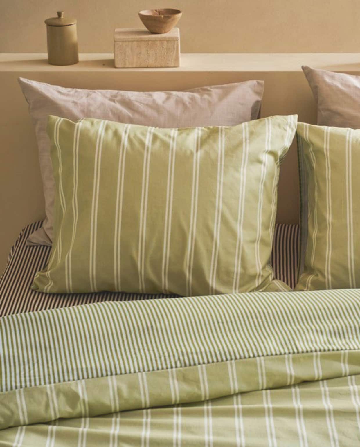 vtwonen dekbedovertrek Mini Stripe, katoen, groen,  vanaf € 59,95, vtwonen hoeslaken Mini Stripe, katoen, naturel, vanaf € 19,95, vtwonen dekbedovertrek Cozy Slub, alleen kussenslopen in beeld, katoen slub, zand, vanaf € 59,95.

M.m.v. hkliving.com (klamboe), versmissen.nl (bijzettafel, rieten hanglamp), burbriantiek.com (oude deuren), zarahome.com (tafellamp). Overig privébezit.  vtwonen landelijk collectie 7-2026 | Styling Cleo Scheulderman | Fotografie Jeroen van der Spek