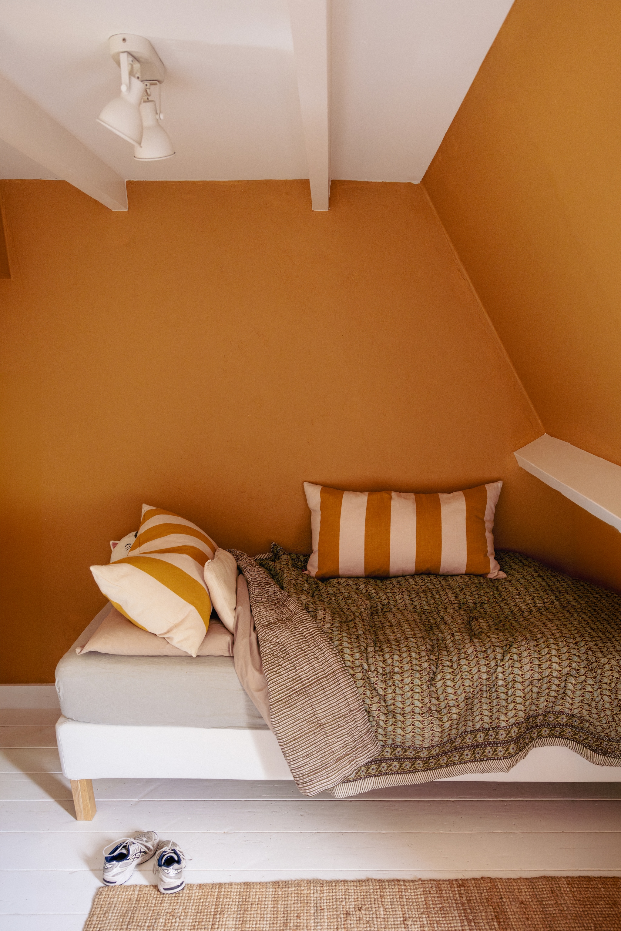 Muur kleur Indian Yellow en plafond en houtwerk kleur All White van Farrow & Ball. Sprei Khasto. Kussens A World of Craft. Beddengoed By Mölle. vtwonen 10-2026 | styling Meta van Grinsven | fotografie Dana van Leeuwen