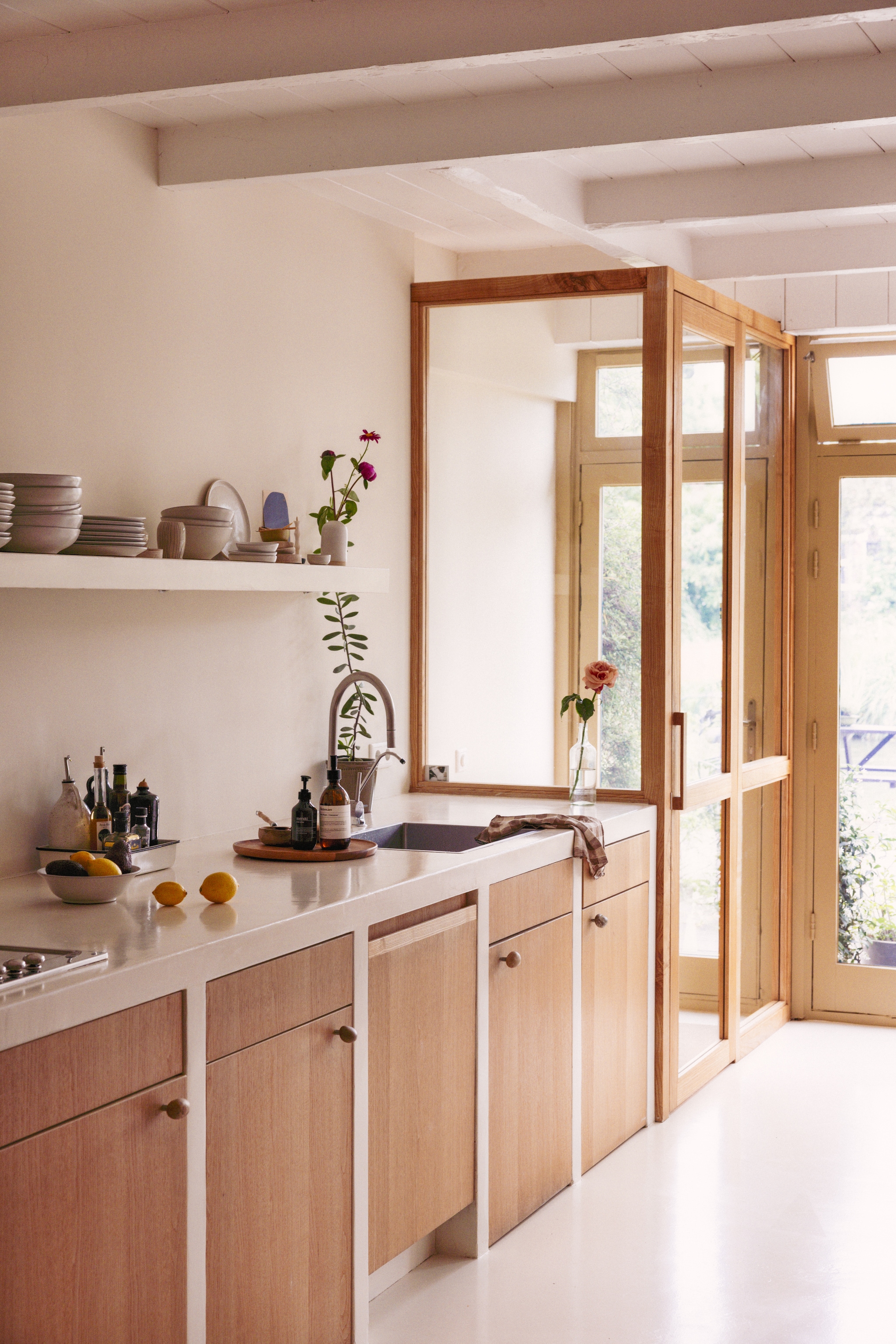 Muur kleur Duster van Farrow & Ball. Keuken zelf gemaakt met beton ciré in kleur White Tie van Farrow & Ball. Servies Atelier Sukha. Wandkleed Elsa Noyons. vtwonen 10-2026 | styling Meta van Grinsven | fotografie Dana van Leeuwen