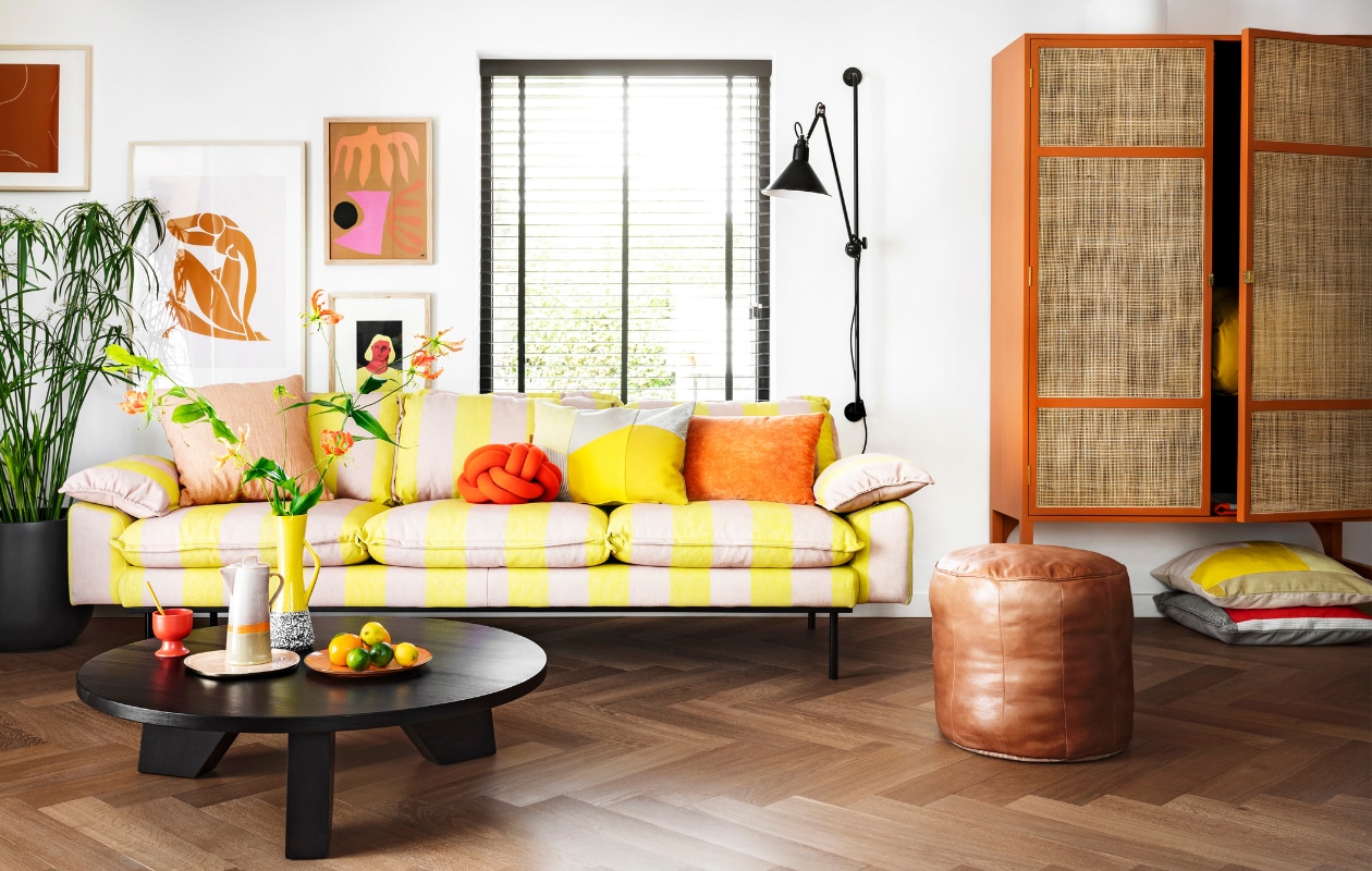 Driezitsbank Retro, 225x95x83 cm € 1925,-, oranje velvet kussen € 37,95, lijst rechtsboven Multi € 69,95, lijst daaronder Art Frame € 59,95, retro kast 125x40x200 cm (bxdxh) € 1495,-, koffiepot Seventies € 39,95, kopje op voet Kyoto € 3,75, dinerbord Peach € 19,95 (hkliving.nl). Kussen met grijze en gele vlakverdeling € 89,- (kus-sen.nl). Oudroze linnen kussen Empire € 45,-, leren poef Virginia € 159,95, salontafel Jay € 499,- (hetkabinet.nl). Sierkussen Knot van Design House Stockholm € 117,-, dienblad Imperfect van &k Amsterdam (vtwonen.nl). Plantenpot Egg € 31,99 (praxis.nl). Plant Papyrus (Tuincentrum). Overig privébezit.