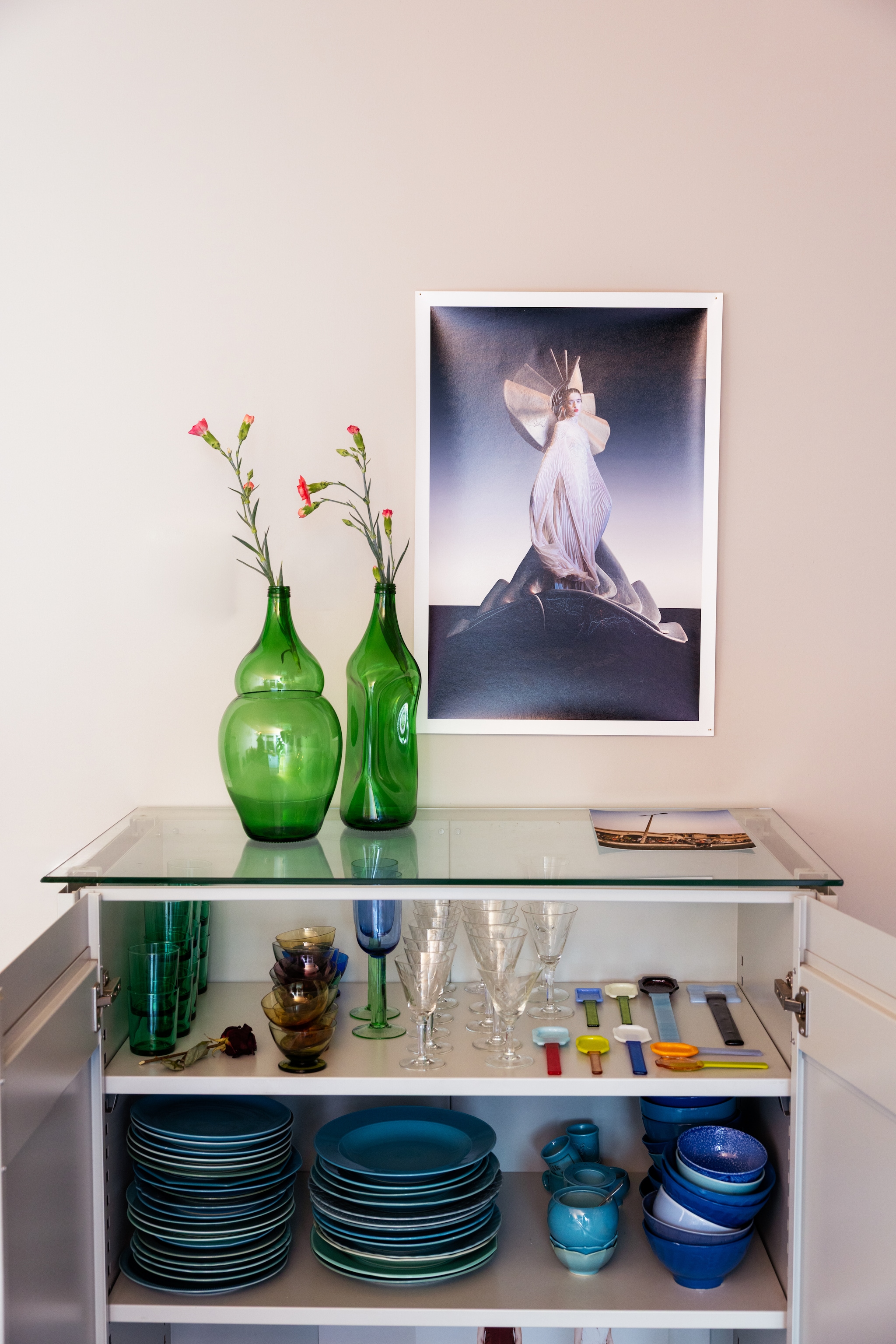 Kast Piet Hein Eek. Poster Maria Bodil. Vazen Klaas Kuiken. Blauw servies Jeanine Eek-Keizer. Glaswerk vintage. Lepels Studio Fleur Peters. vtwonen 10-2026 | styling Djolien De Kreij | fotografie Dana van Leeuwen