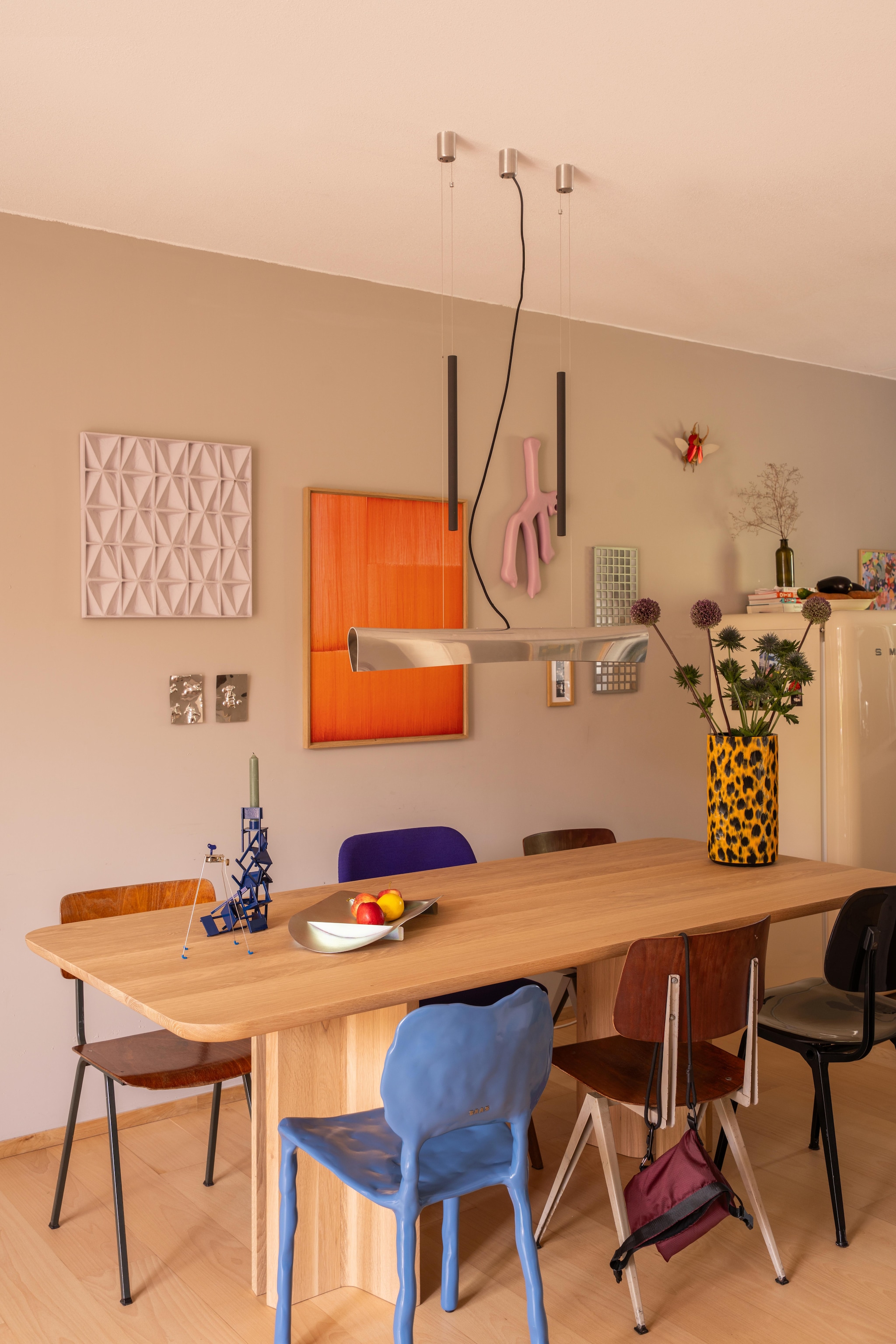 Tafel Onno Adriaanse x Table du Sud. Blauwe stoel Clay van Maarten Baas. Zwarte stoel Revolt van Friso Kramer. Bruine stoelen kringloop. Hanglamp Nil van Jörg Zeidler voor Anta via Marktplaats. Schaal Tension van Paul Coenen. Object Critter van Kikkerland. Kandelaar Chairholders van Dirk Duif. Vaas Leopard van Rik van Veen via Offsite. Metalen plaatjes op wand Car Crashes van Job van den Berg. Oranje werk Ronan Bouroullec. Lila object Gravity Man van Atelier Fig. Spiegel Dangling van Alissa+Nienke. Insect Assembli. Tweedehands houten vloer behandeld met matte lak van Skylt. vtwonen 10-2026 | fotografie Lotte van Uittert