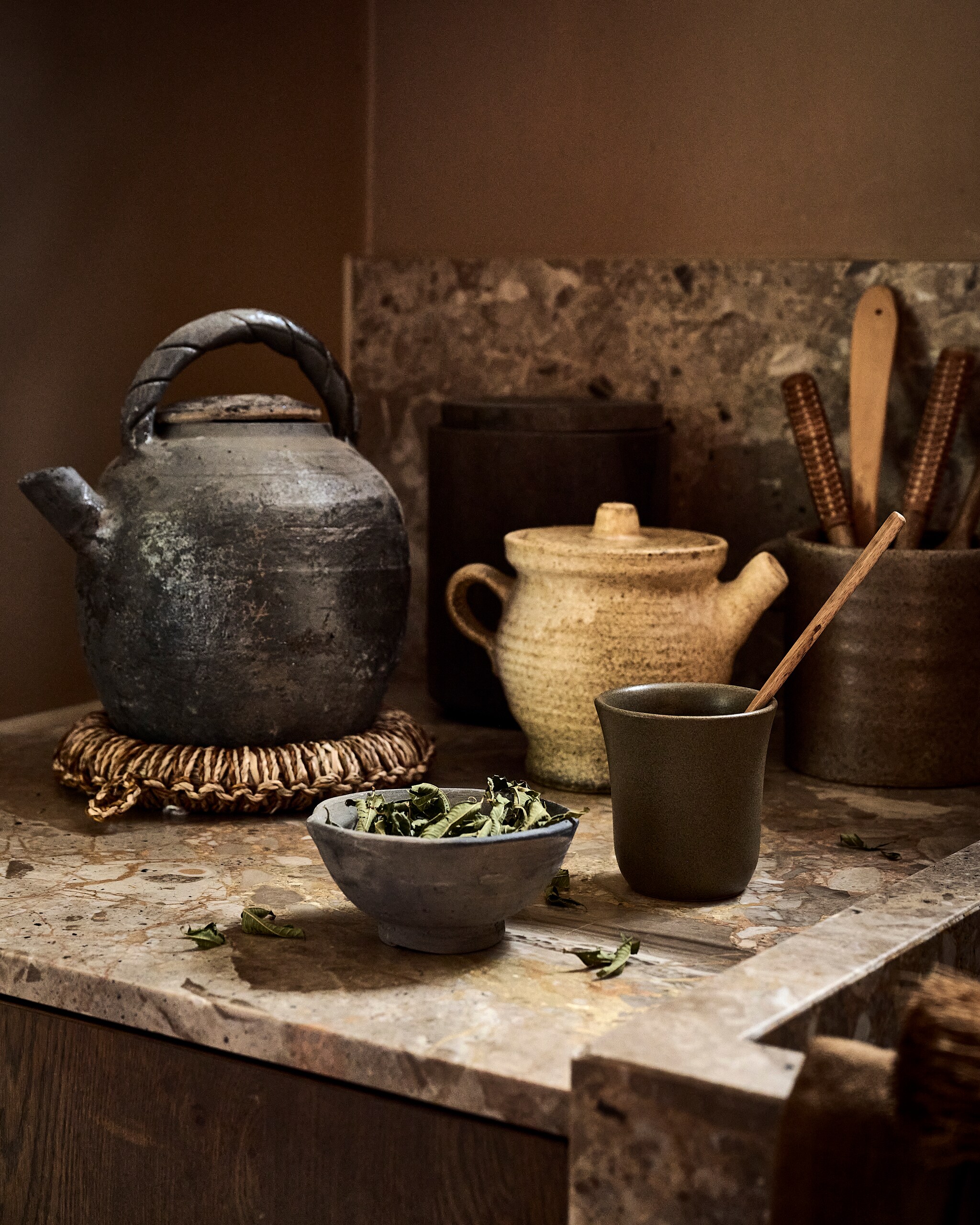 Luksa Home Collection theepot, oud metaal € 39,-, kom, grijs € 7,50, voorraadpot met deksel, grijs, set van 3 € 99,- (luksa.furniture). Madam Stoltz onderzetter € 17,75, lepels, hout en bamboe, set van 2 € 27,50 (madamstoltz.dk). Ro Smit beker, aardewerk € 15,95 (rosmit.nl). Pand40 pot met grepen € 34,09, lepel, hout, set van 2 € 7,58 (pand-40.nl). Studio Bazar pollepel, hout € 4,95 (studiobazar.com). Overig privébezit. vtwonen landelijk 9-2026 | styling Danielle Verheul | fotografie Sjoerd Eickmans