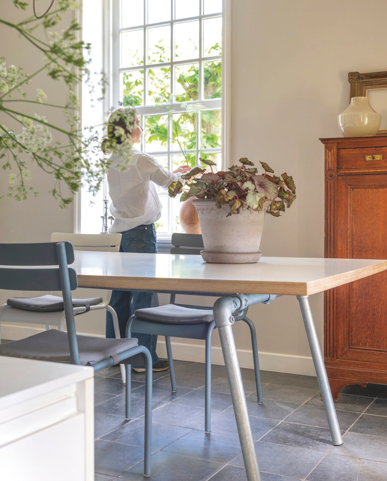 Eettafel gemaakt door Roel Westerman. Meidenkastje kocht Astrid van haar eerste geld. Pot Toscaans terracotta Bergs Potter. Vloertegels Vietnamees hardsteen. vtwonen Landelijk 7-2026 | fotografie Suzanne Paap