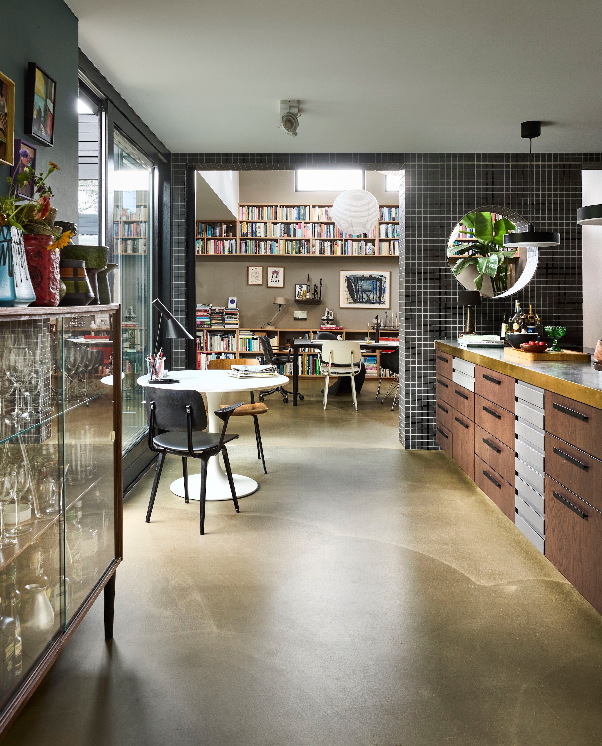Tafel Ikea. Zwarte stoel Revolt van Ahrend vintage. Houten stoel heruitgave Revolt van Hay. Tafellamp Louis Poulsen. Plafondlamp Zuiver. Boekenkasten maatwerk.