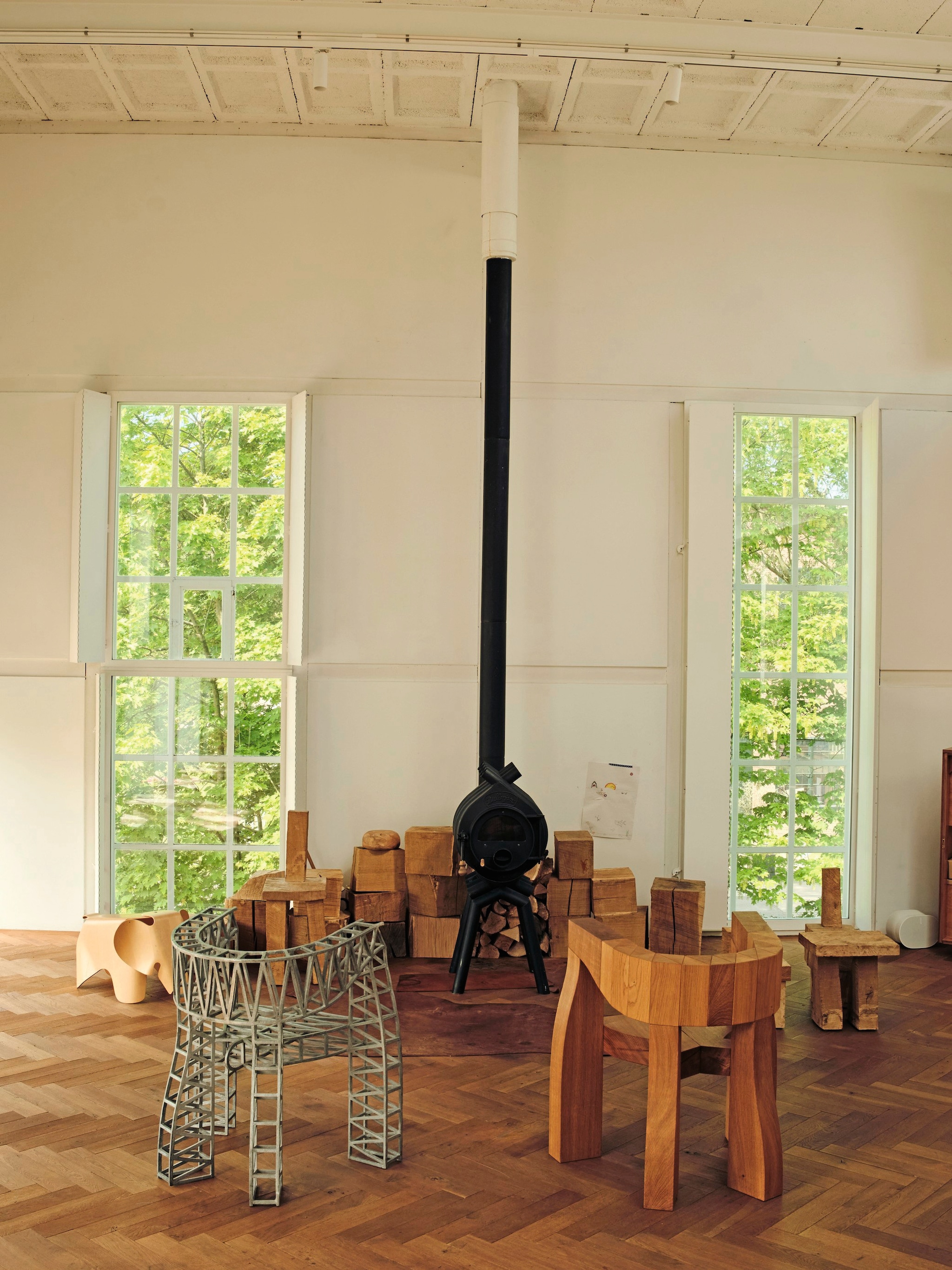 Houtkachel Bullerjan. Stoelen Bridge Chair in hout en in aluminium Studio Molen. Overige houten (kinder)stoelen Arne Kristian. Houten olifant Eames via Wonderwood vtwonen design 7-2026 | fotografie Oof Verschuren