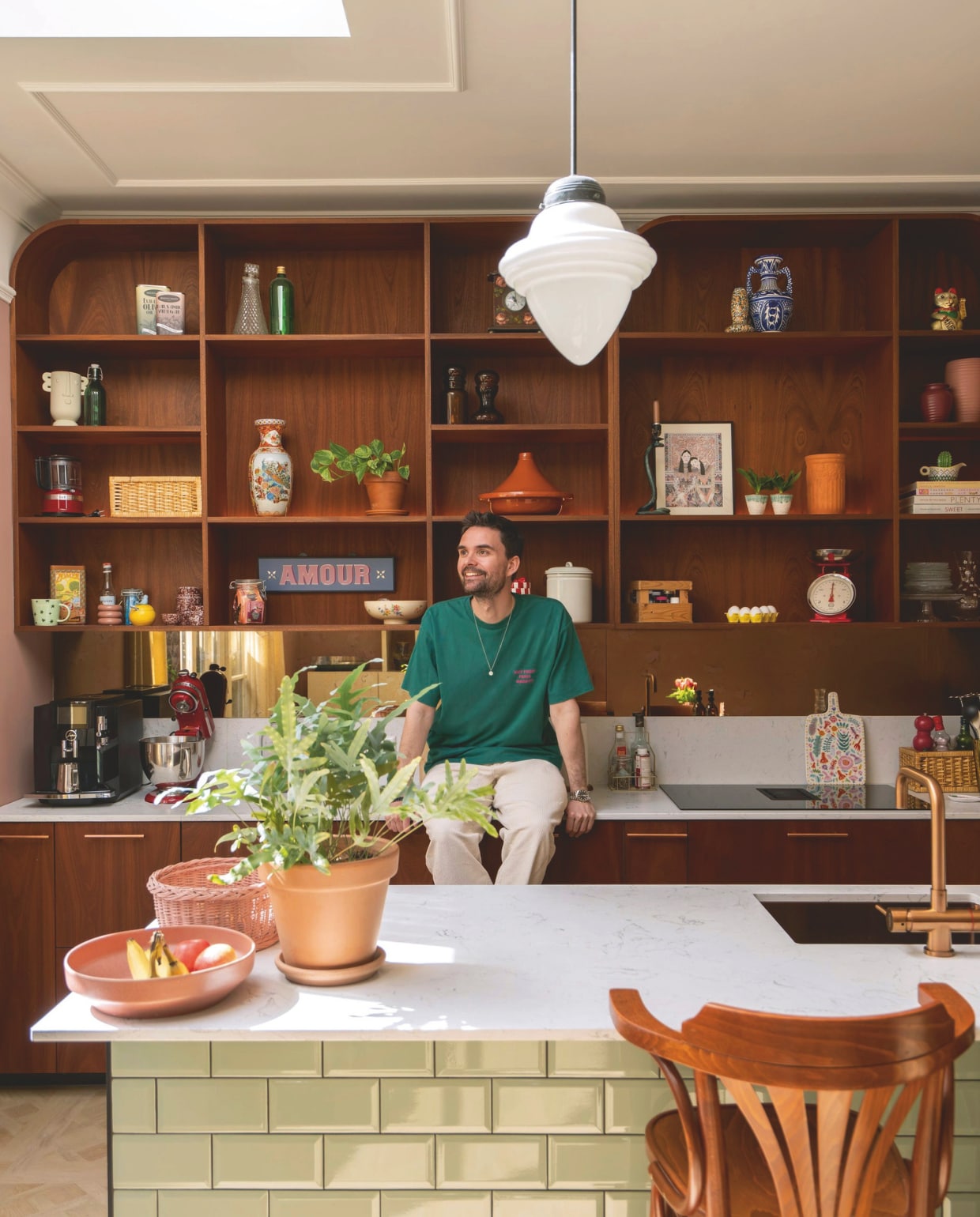 Op maat gemaakte keuken met kwartscomposiet werkblad en maatwerk in mahoniehout Schaalwerk. Metrotegels in jade groen van Tegels in Huis. Barkruk vintage. Vintage hanglamp uit bar. Koperen kraan Selsiuz. Accessoires voornamelijk kringloop. vtwonen 09-2026 | fotografie Lotte van Uittert