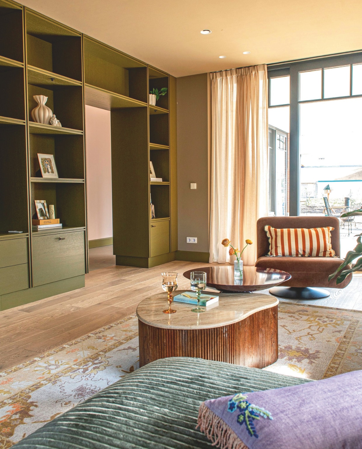 Maatwerk kasten geschilderd in Hunter van Lab Paint. Vouwgordijnen Gotain. Kleur op de muur zelf gemengd. Bank Micadoni. Stoel Zara Home. Salontafel met hout Giga Meubel. Ronde bijzettafel, rond roze kussen en vloerkleed Sissy-boy. Langwerpig kussen Zara Home.  Overige kussens Rice. Lamp HKliving. Wijnglazen Westwing.