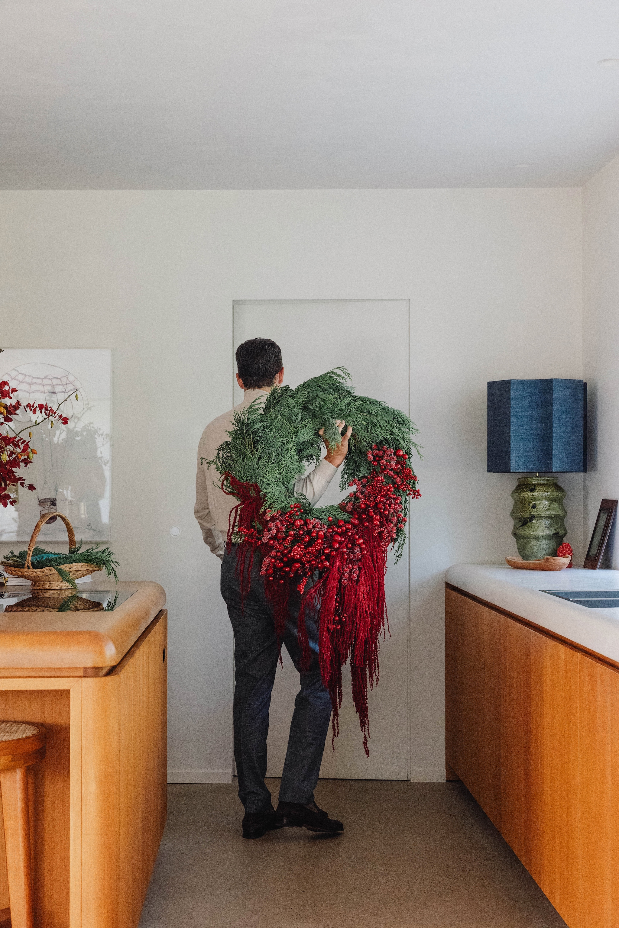 Kerstkrans Olivier De Croock. Sfeerlamp van vintage vaas met kap van René Houben. Ernaast een spiegel van Jo’s grootvader. vtwonen Design 9-2026 | fotografie Stie De Neve