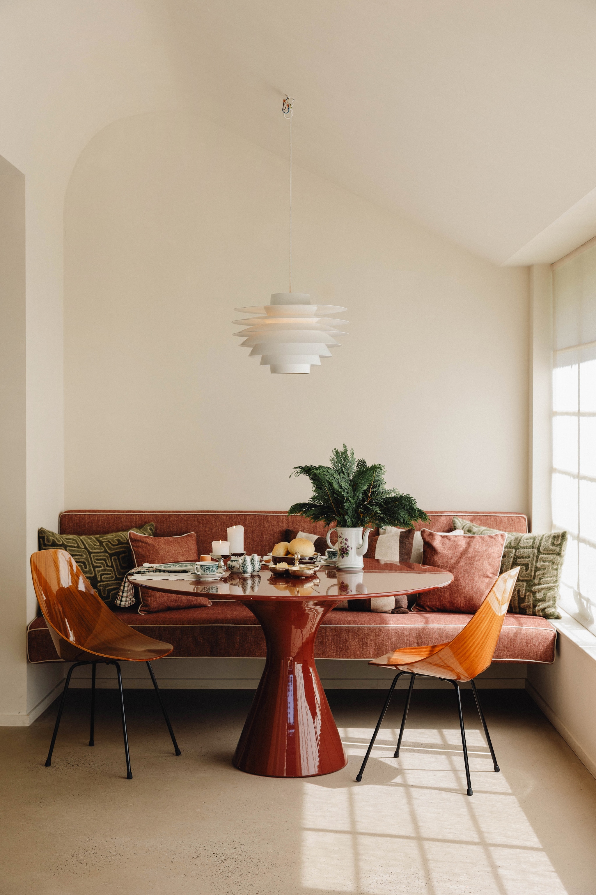 Hoogglans tafel eigen ontwerp. Vintage kuipstoelen Medea van Vittorio Nobili. Vintage lamp Verona, ontworpen door Svend Middelboe. Stof muurbank Designs of the Time. vtwonen Design 9-2026 | fotografie Stie De Neve