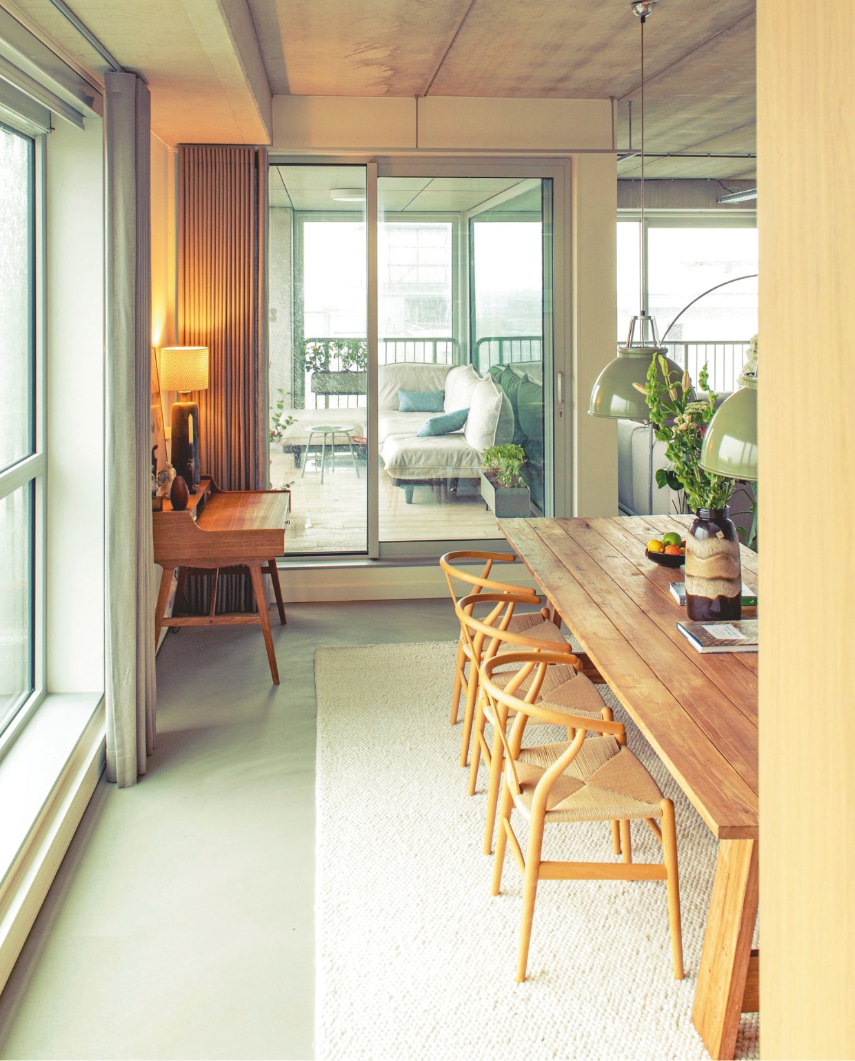 Tafel Loods 5. Stoelen Wishbone van Hans J. Wegner voor Carl Hansen & Søn. Hanglampen Titan van Original Btc. Vloerkleed Trendcarpet. Bureau van Arne Wahl Iversen voor Vinde Møbelfabrik, vintage. Gordijnen Van Eijk Interieur. Buitenbank Fatboy. vtwonen 09-2026 | fotografie Caroline Coehorst