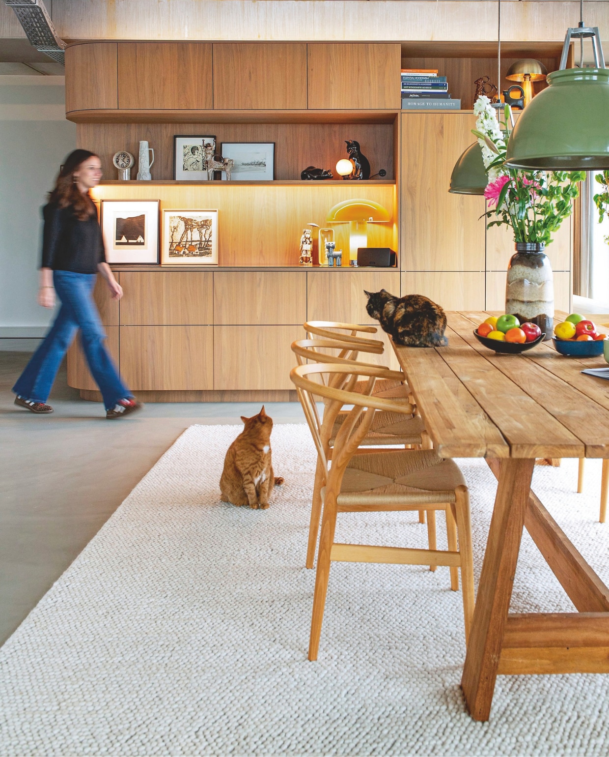 Multifunctioneel meubelblok ontworpen door Vervoort Architecten, uitgevoerd in shinnoki frozen walnut door Vos Interieur. Tafel Loods 5. Stoelen Wishbone van Hans J. Wegner voor Carl Hansen & Søn. Hanglampen Titan van Original Btc. Klok en tafellamp Lounge mocha van HKliving. Vloerkleed Trendcarpet. Lavasteen gietvloer Berkers Vloeren. Vintage kunstwerken: zwart-wit lithografie van Albert Bertelsen, kleurenets van Alfons Blomme, ets Meisje met kat van Britta Nehrman. vtwonen 09-2026 | fotografie Caroline Coehorst