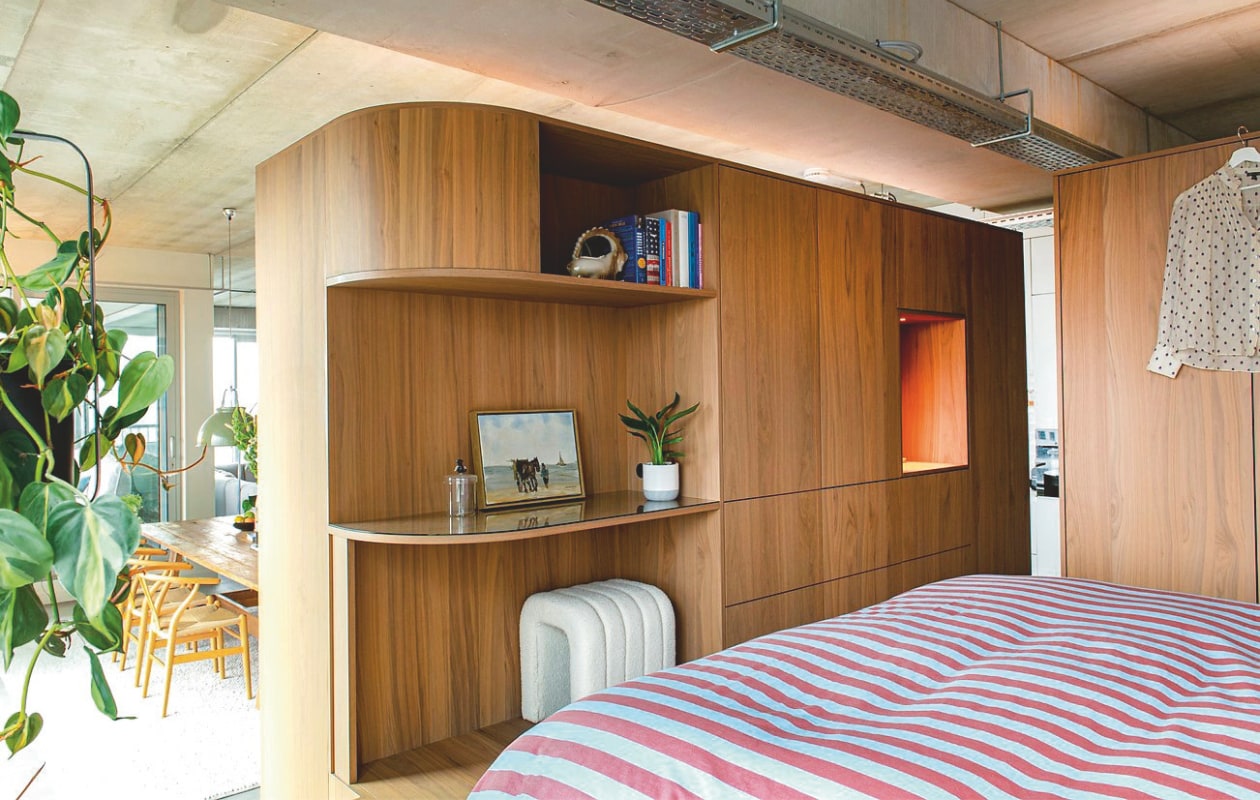 Multifunctioneel meubelblok ontworpen door Vervoort Architecten, uitgevoerd in shinnoki frozen walnut door Vos Interieur. Bed Essential van Auping. Dekbedovertrek Tbco. vtwonen 09-2026 | fotografie Caroline Coehorst