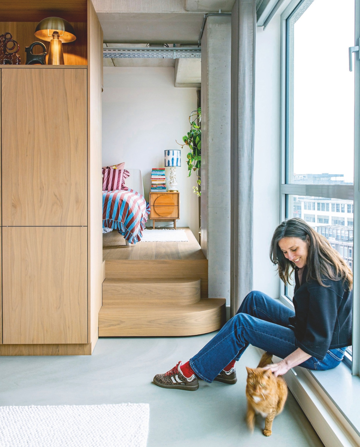 Multifunctioneel meubelblok ontworpen door Vervoort Architecten, uitgevoerd in shinnoki frozen walnut door Vos Interieur. Bed Essential van Auping. Dekbedovertrek Tbco. Nachtkastje Groove van Zuiver. Lampenkap Studio Limonada. Gouden lamp Kwantum.