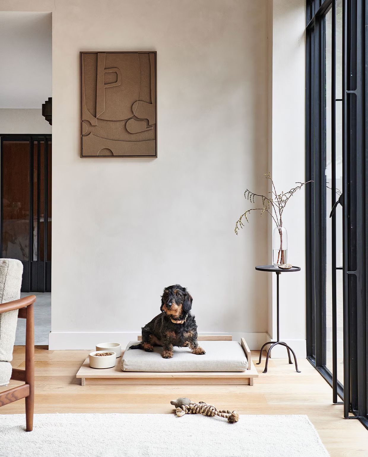 Beige fauteuil Todd € 955,- (vtwonen.nl). Ronde metalen tafel met antieklook € 79,99, speelgoedkikker voor dieren € 15,99, wollen tapijt, 160×230 cm € 249,- (zarahome.com). Glazen vaas Una € 27,- (bolia.com). Hondenhalsband Doga, steengrijs met roségoud € 39,95, witte massief betonnen voerbak € 59,95 (dogahaves.nl). Op maat gemaakt linnenlook kussen, stof uni grof, 50x70x6 cm € 72,78 (nofruit.nl).