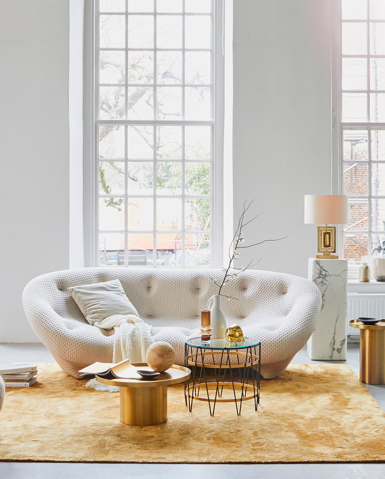 4-zitsbank Ploum van Ligne Roset, 124x84x253 cm (dxhxb) vanaf € 4633,-, okergeel vloerkleed Soft van Jov 260×300 cm € 2738,-, messing bijzettafels, 60×31 cm (Øxh) € 598,-, 43×47 cm (Øxh) € 548,- (misterdesign.nl). Bijzettafel met glas en metaal, Ø 50 cm € 550,-, lamp van messing met zijden kap € 750,- (paullelieveld.com). Marmeren pilaar, 33x33x91,4 cm (lxbxh) € 425,-, voetenbankje Pebble € 150,- (polspotten.nl). Linnen plaid € 275,-, okergele vaas € 18,20 (nordal.eu). Grijs fluwelen kussen € 26,50, vaas bladdessin € 27,- (madamstoltz.dk). Zwarte kommen € 25,- (vtwonen.nl). Overig privébezit. vtwonen 02-2019 | styling Cleo Scheulderman | fotografie Jeroen van der Spek
