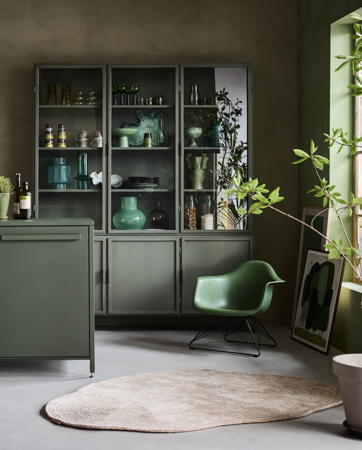 Lab Paint kalkverf, links Limited Jade en rechts Tokyo Tea, 1 liter € 66,-(vestingh.nl). Keuk keuken, groen bovenblad, met basisapparatuur vanaf € 5000,- (keuk.nl). New Routz buffetkast Garland, metaal, olijfgroen, 183x43x222 cm (bxdxh) € 2495,-, Pstr Store poster Woodblock Print III, papier, wit en groen, 70x100 cm € 83,-, poster Grove van Marco Marella, papier, wit en groen, 50x50 cm € 58,- (shop.vtwonen.nl). Vitra loungestoel Lar, kunststof en metaal, 62,5x61x63,5cm (bxdxh) € 565,- (loods5.nl). Casalis vloerkleed, textiel, naturel, prijs op aanvraag (casalis.be). Polspotten bijzettafel Pumpkin, aardewerk, groen € 220,- (polspotten.nl). Servies in de kast en op het schap: HKliving hoge glazen 70’s L, groen, set van 4 € 39,-, glazen 70’s bulb, lichtgroen, set van 4 € 30,-, wijnglazen, groen, set van 4 € 46,95, laag glas Tube, olijfgroen € 8,50, karaf Tube, olijfgroen € 19,95, bekers, aardewerk, geel en bruin € 19,95, koffiekop met oor, aardewerk, bruin € 8,75, beker, aardewerk, groen en bruin € 7,50, schaal op voet The Emerald, aardewerk, groen € 54,99, schaaltje Oyster, aardewerk, groen € 25,-, schaal Shell, aardewerk, blauw en groen € 72,-, schaal op voet, aardewerk, privébezit, bord 70’s, aardewerk, zachtgroen € 27,95, bord Chef, groen € 15,-, bord The Emeralds, donkergroen € 24,95, hanglamp Ceramic, aardewerk, oker € 149,- (hkliving.nl). Urban Nature Culture vaas, gerecycled glas, transparant € 14,99, vaas,gerecycled glas, flessengroen € 29,99, vaas Collo Reseda M, glas, lichtgroen € 39,95, kandelaar Sopra, bol glas, olijfgroen € 24,99 (shop.vtwonen.nl). Ansichtkaarten € 1,- (artunlimited.nl). Ikea pan Hemkomst, aluminium € 49,95, voorraadpot Korken in de kast € 2,79 (ikea.com). Theedoeken, katoen, groen en wit € 7,95 (dille-kamille.nl). Planten met pot en oude schaal op voet privébezit.