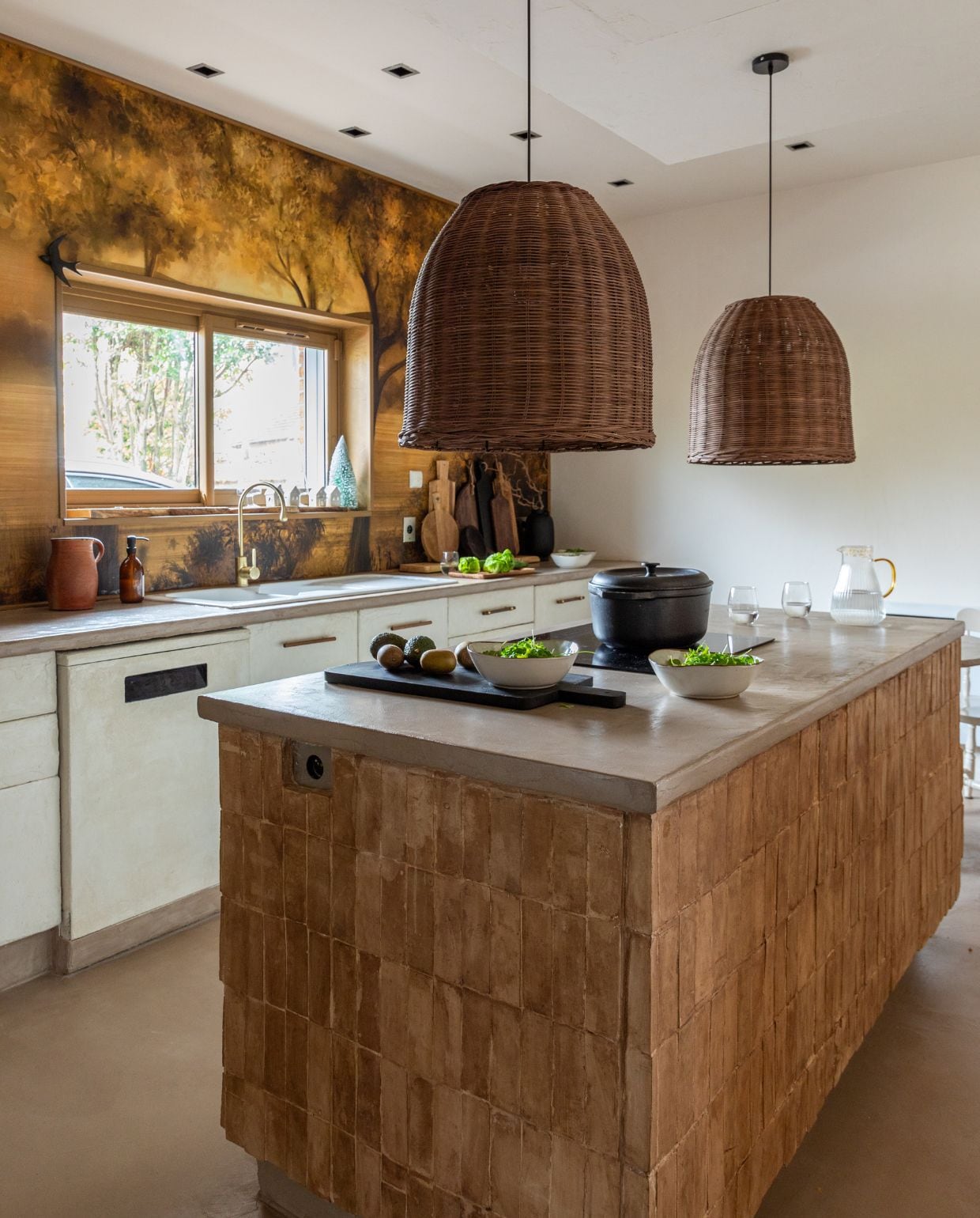 Behang Maison Deco. Hanglampen Las Sola. Werkblad en vloer Maison Étanche. Kraan 123Bain. Keukeneiland betegeld met bejmat tegels van Maison Zellige. Zwarte snijplanken Floraux. Stoofpan Le Creuset. Karaf L’Incroyable. Glazen Maxi Bazar. Schalen Alinea. vtwonen Kerstspecial 2025 | styling Marie-Maud Levron | fotografie Cecile Perrinet Lhermitte