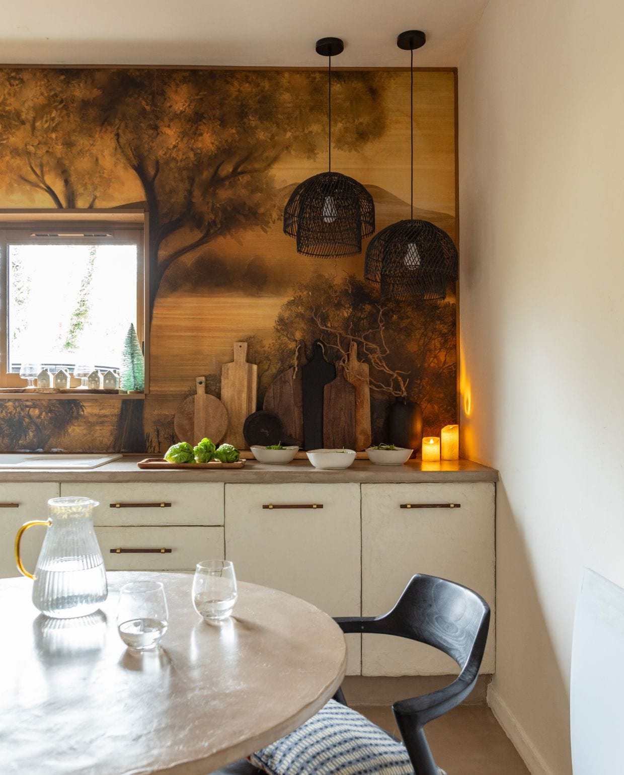 Behang Maison Deco. Hanglampen Las Sola. Werkblad en vloer Maison Étanche. Kraan 123Bain. Keukeneiland betegeld met bejmat tegels van Maison Zellige. Zwarte snijplanken Floraux. Stoofpan Le Creuset. Karaf L’Incroyable. Glazen Maxi Bazar. Schalen Alinea. vtwonen Kerstspecial 2025 | styling Marie-Maud Levron | fotografie Cecile Perrinet Lhermitte