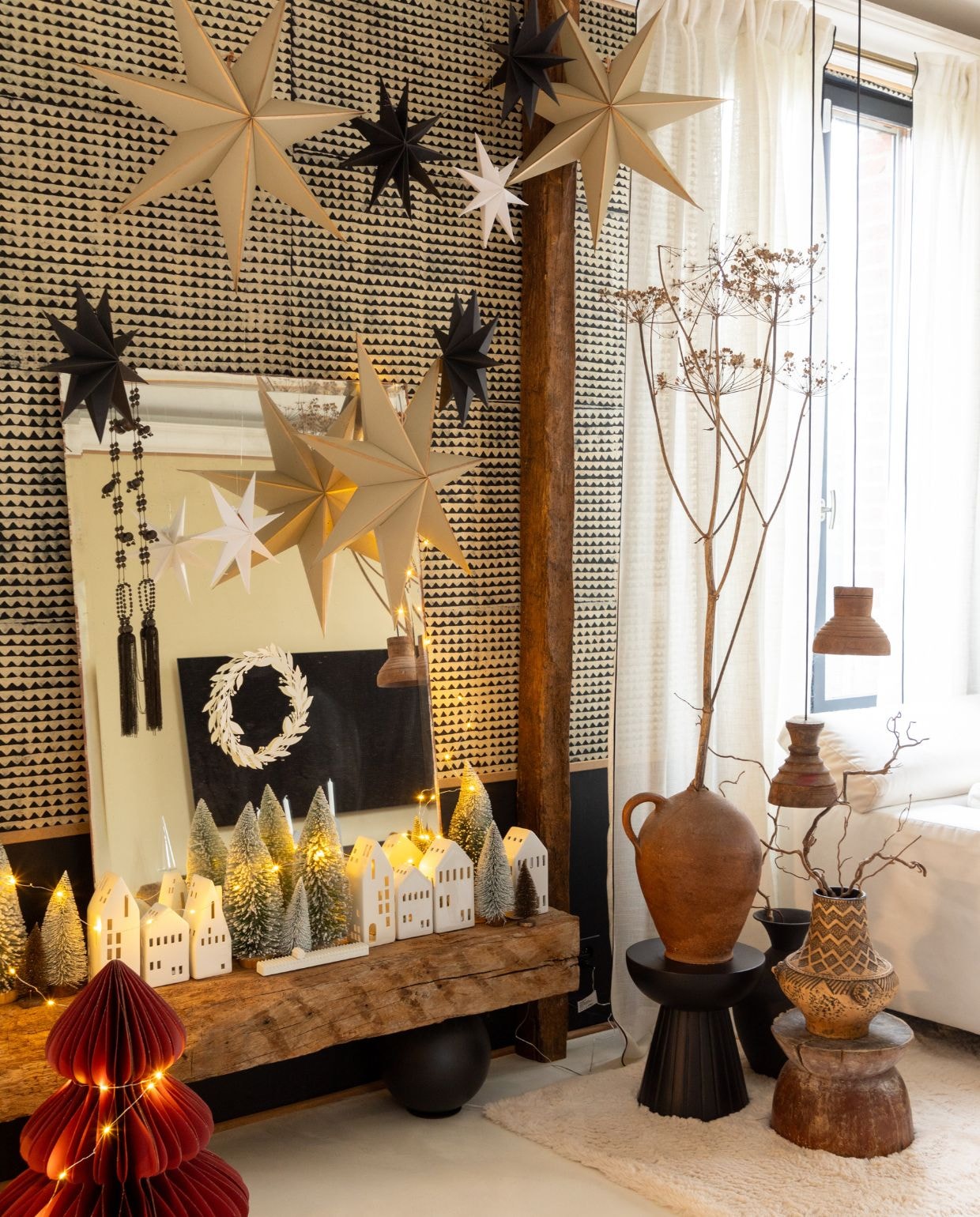 Bankje zelfgemaakt. Spiegel tweedehands. Sterdecoratie Amazon. Keramieken huisjes Authentique in Noailles. Krans gemaakt door Eve. Papieren kerstboom L’Incroyable. vtwonen Kerstspecial 2025 | styling Marie-Maud Levron | fotografie Celine Perrinet Lhermitte