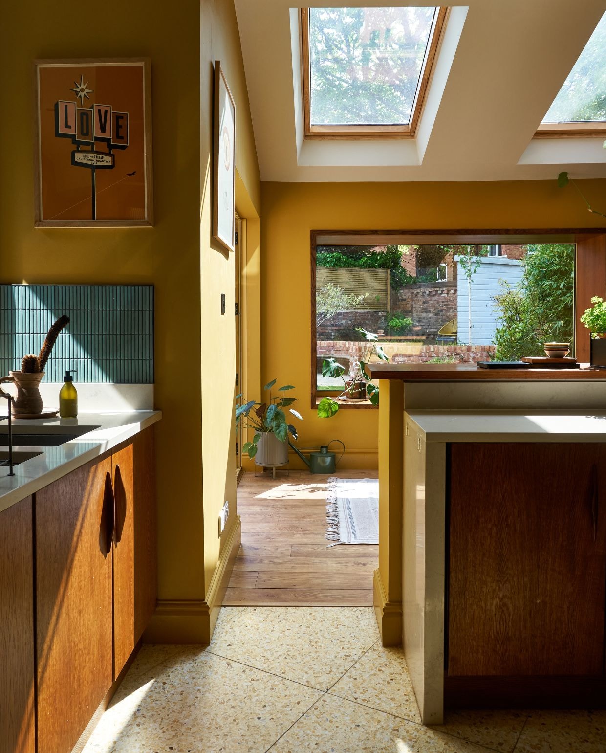 Op maat gemaakte keuken David March Furniture. Vloer- en muurtegels Mosaic Factory. Muurverf India Yellow van Farrow & Ball, poster Object. vtwonen 11-2024 | fotografie Claire Bingham