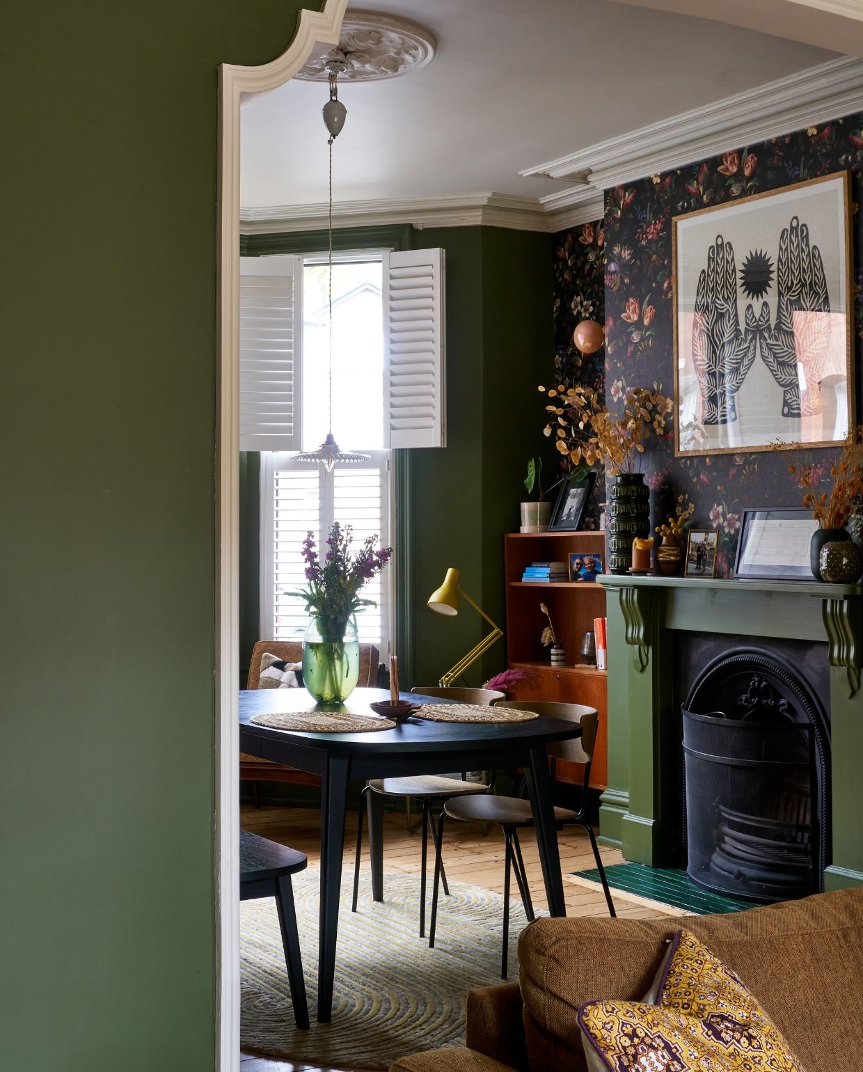 Gele lamp Anglepoise. Behang House of Hackney. Kunst boven schouw via Object. Vloerkleed Anthropologie. Eettafel Habitat. Stoelen Ferm Living. Overig vintage. vtwonen 11-2024 | fotografie Claire Bingham