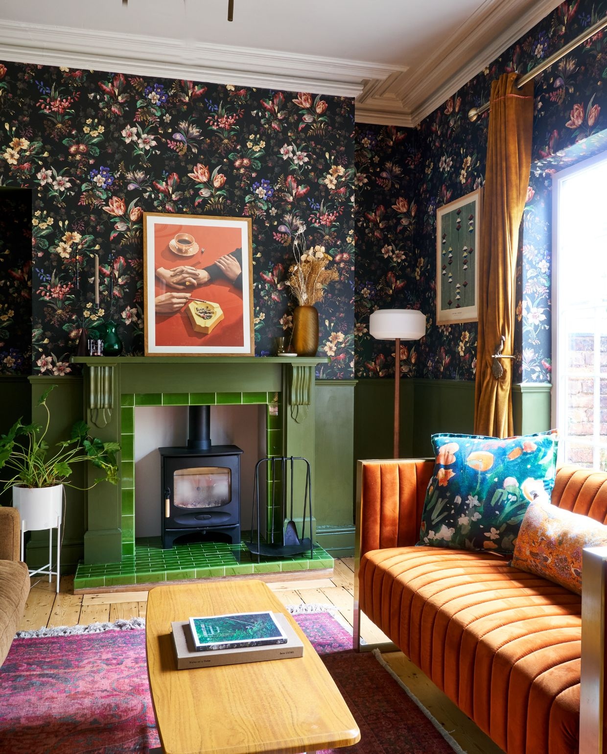 Oranje bank Rockett St. George. Vloerkleed French Connection Home. Vaas en bloempot Hübsch. Gordijnen Made. Gordijnhaak Anthropologie. Tafel vintage. Haardaccessoires Black Fire Accessories. Kussens Izzy Izzy Studio. Verf Olive van Little Greene. Kunst op schouw Henrik Bülow, behang Tulipa van House of Hackney.
