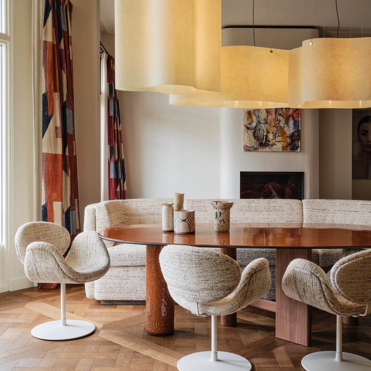 Gordijnen District Claret van Kelly Wearstler via Mcveer Collections. Tafel Sengu van Cassina via Edha Interieur. Bank maatwerk Linteloo via Edha Interieur, met stof Clay Kaduna van Larsen. Stoelen Artifort, met stof Clay Kaduna van Larsen. Keramiek op tafel Mel Lennon via Atelier ND Interior. Kunstwerk boven schouw Niek de Vriendt. Haard ontworpen door Atelier ND Interior en gerealiseerd door Jos Harm. Muur behandeld met stucco-verf in kleur Saint-Tropez van Wow Makers. Lampen Nuvola van Draga & Aurel via Baxter. vtwonen design 8-2026 | fotografie Space Content Studio