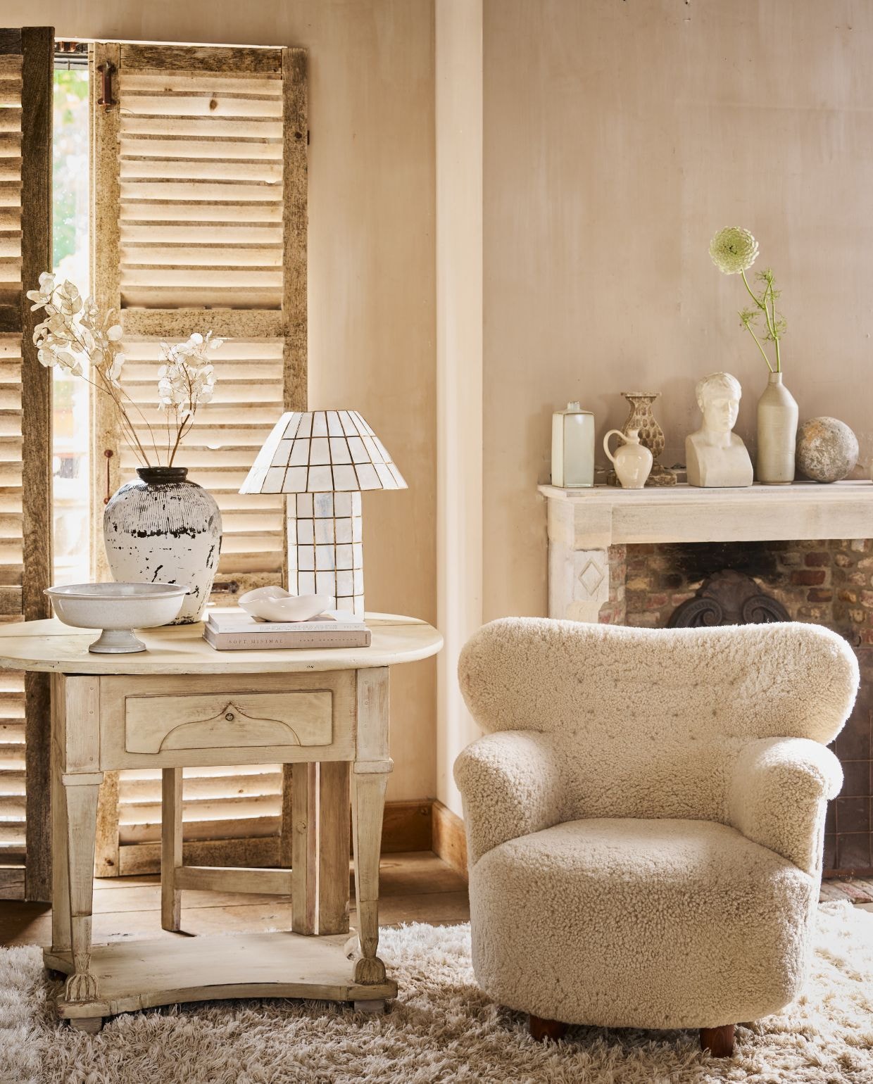 Dusty Deco fauteuil Elias Sheepskin, 72x80x73 cm (bxdxh) € 4400,-, tafellamp Cornelia € 490,- (dustydeco.com). Zuiver vloerkleed Curly, schapenwol, 160x230 cm (bxl) € 499,- (shop.vtwonen.nl). Prinsheerlijk Antiek Zweedse tafel, 70x74 cm (Øxh) € 1250,-, hoofd, gips € 95,- (prinsheerlijkantiek.nl). H&m Home schaaltje € 24,99, schaal op voet € 39,99, flesvaas, rechthoekig € 19,99 (hm.com). Marjoke de Heer fles, keramiek, prijs op aanvraag (marjokedeheer.com). Luksa olijfpot, Aziatisch, whitewash € 99,- (luksa.nl). ’t Achterhuis luiken, antiek, hout, prijs op aanvraag (achterhuis.nl). Overig privébezit. vtwonen Landelijk 10-2026 | styling Cleo Scheulderman | fotografie Jeroen van der Spek